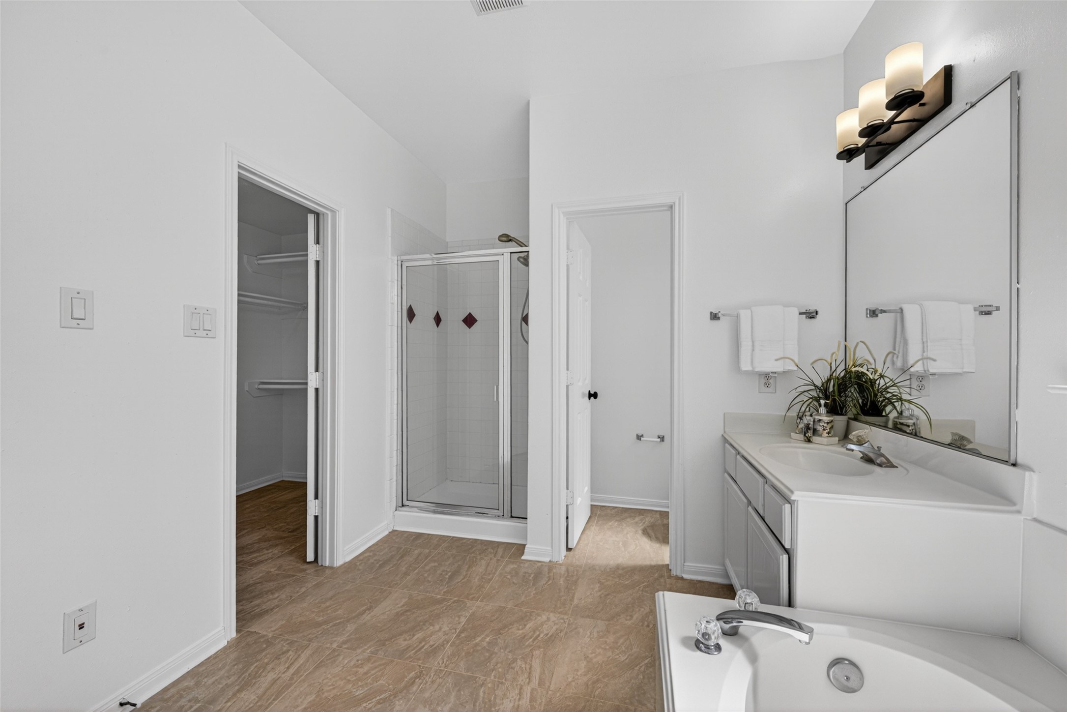 The versatile upstairs game room is a sprawling space anchored by rich wood flooring and bathed in natural light from large windows.