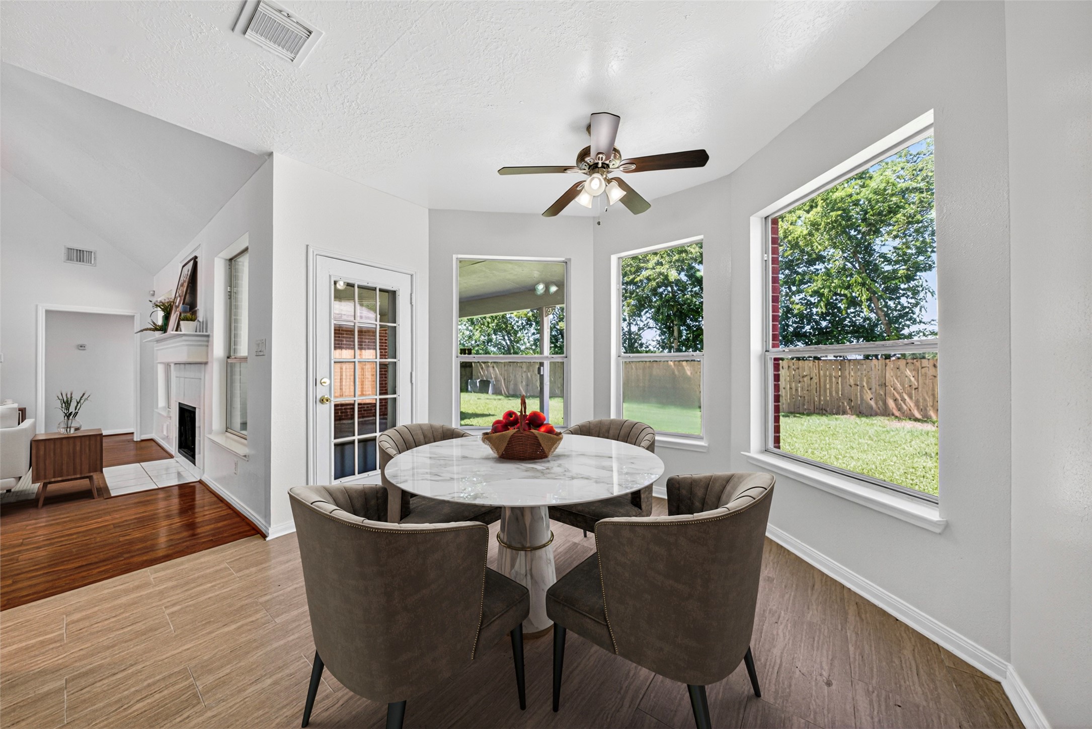 This cheerful space features a charming bay window design and a stylish ceiling fan, creating a comfortable spot for casual meals or your morning coffee.