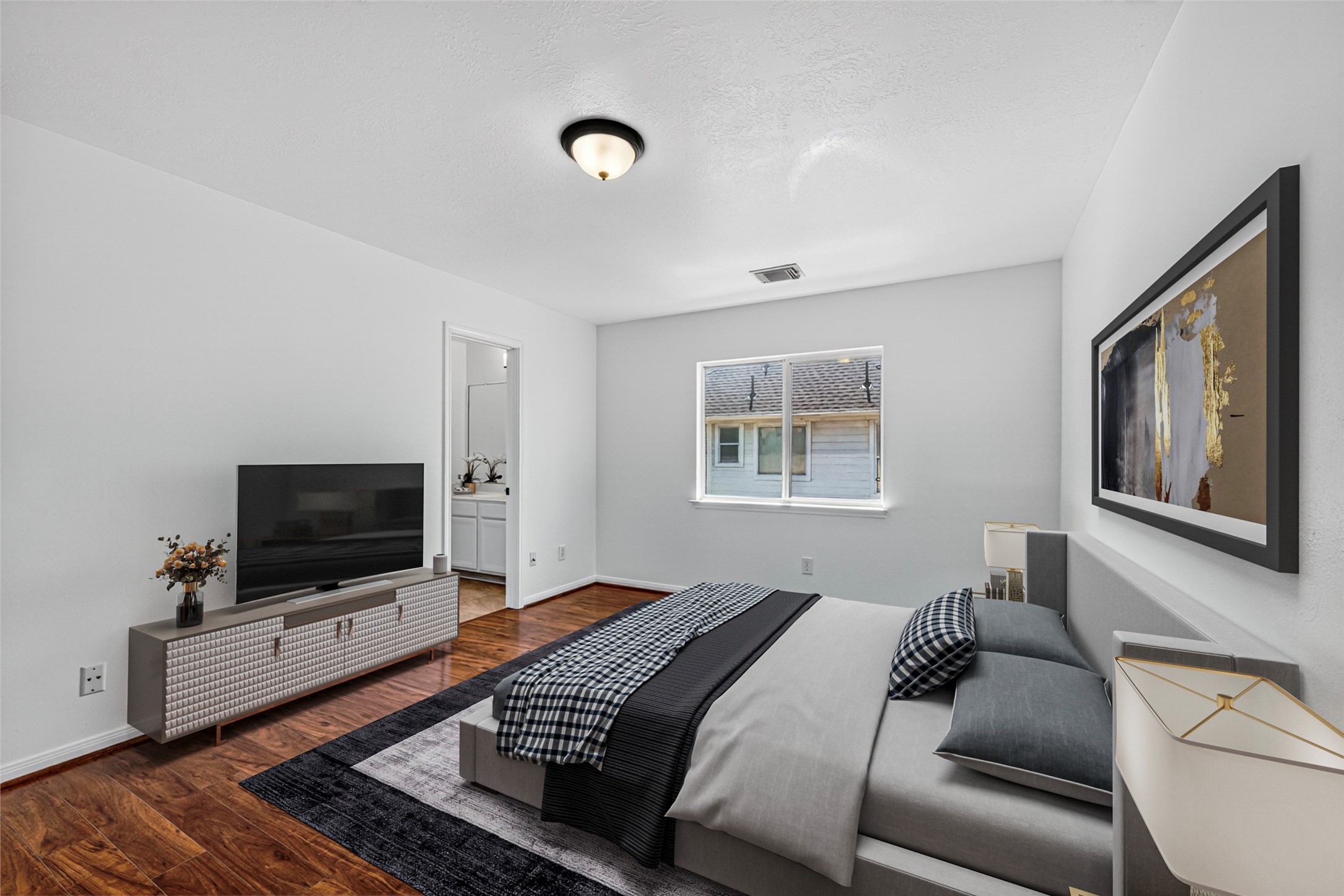 This quiet fifth bedroom serves as a versatile sanctuary, featuring warm wood flooring and a view that captures the gentle light of the day.