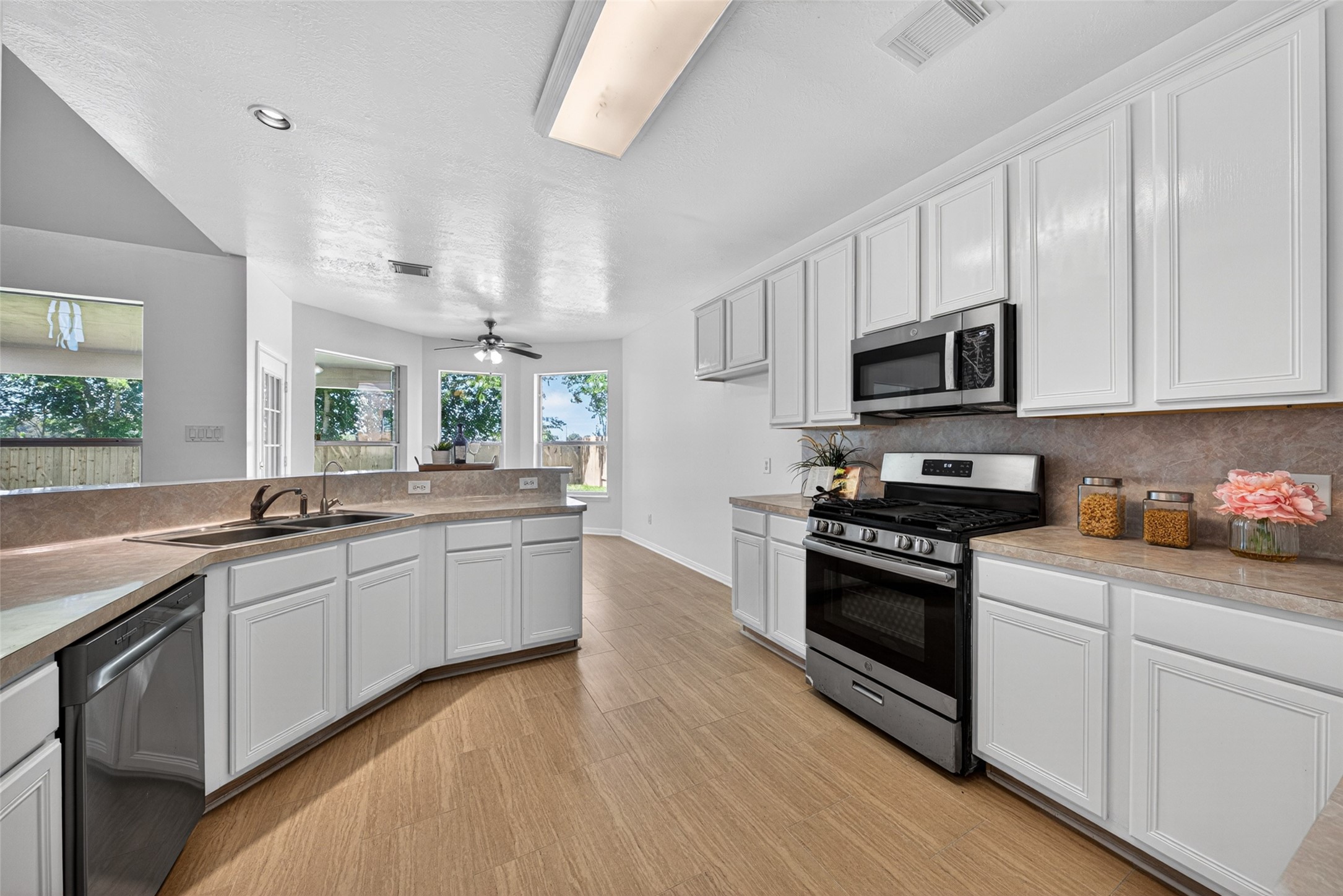 The chef-inspired kitchen features an abundance of pristine white cabinetry contrasted by elegant granite countertops.
