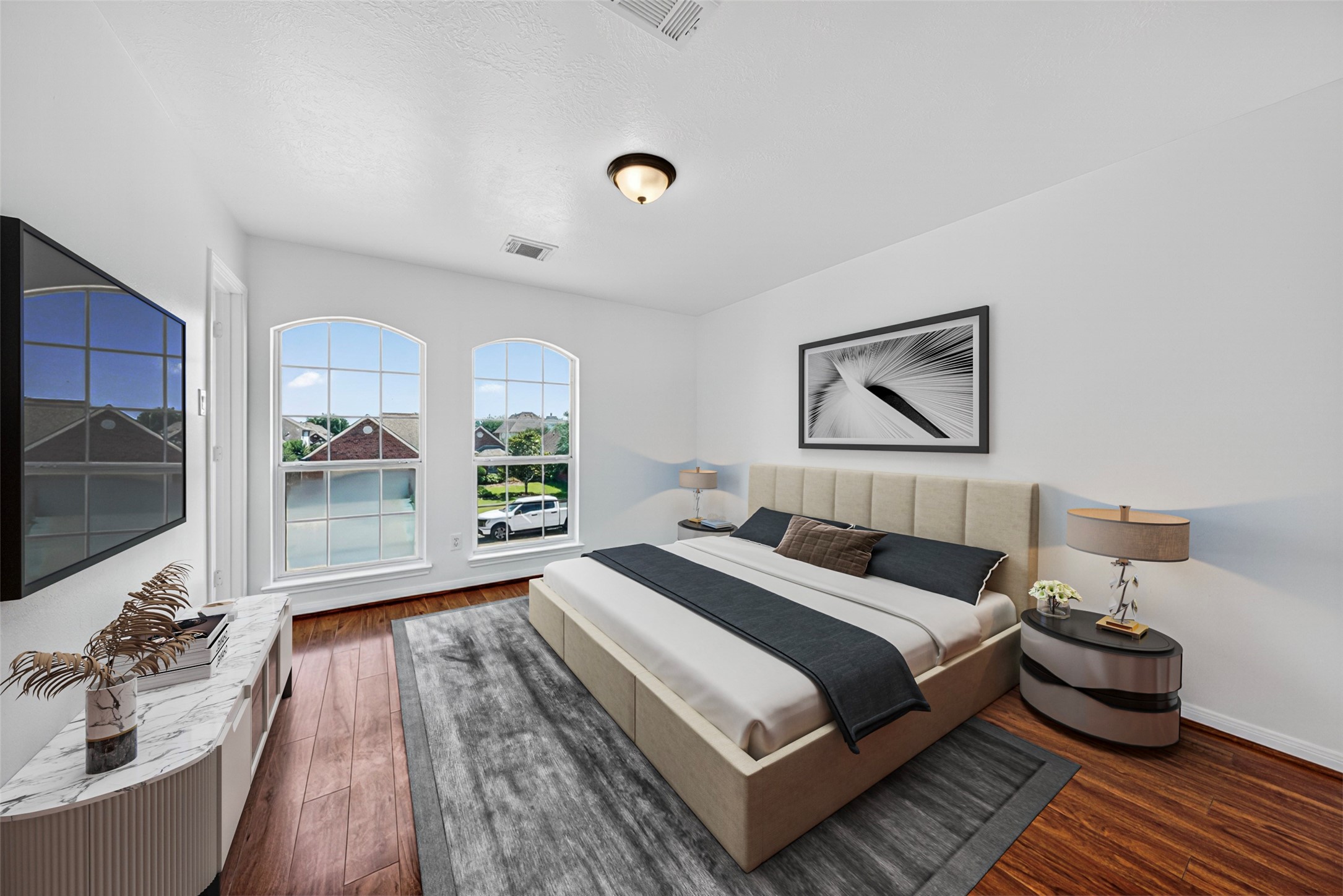 This serene fourth bedroom offers a bright and refreshing atmosphere, highlighted by elegant arched windows that fill the space with abundant natural light.