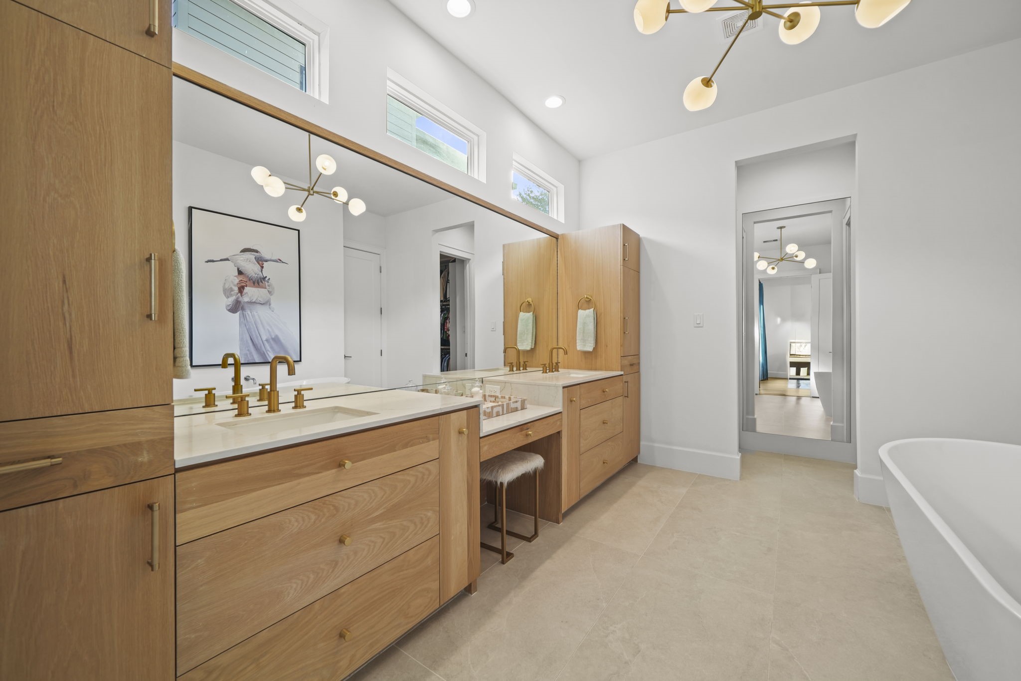 The primary bathroom is stunning! Gold finishes, windows and a full length mirror add to the custom touches!