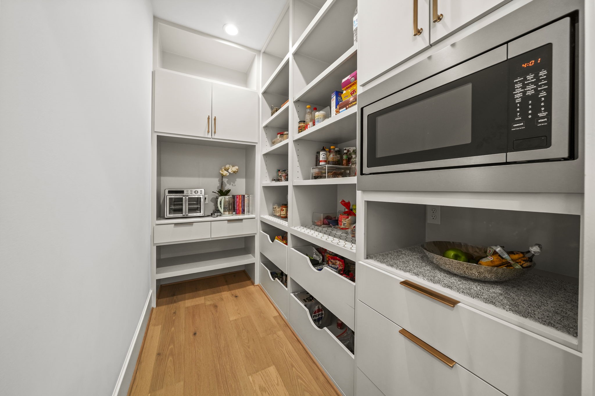 This pantry is amazing! The microwave is hidden in this room and custom built ins provide a great way to stay organized!