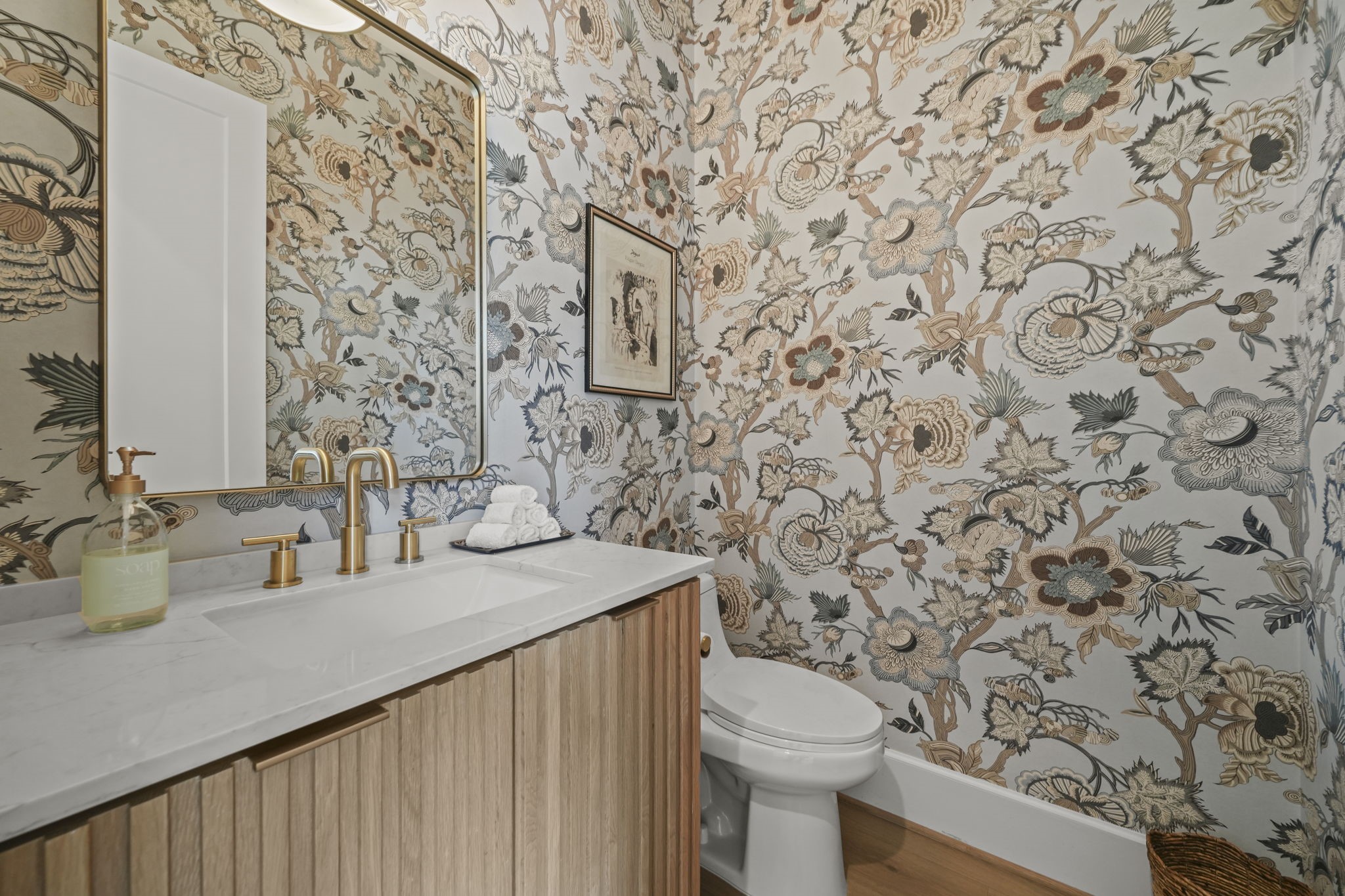 The half bath with custom wallpaper and gold finishes!