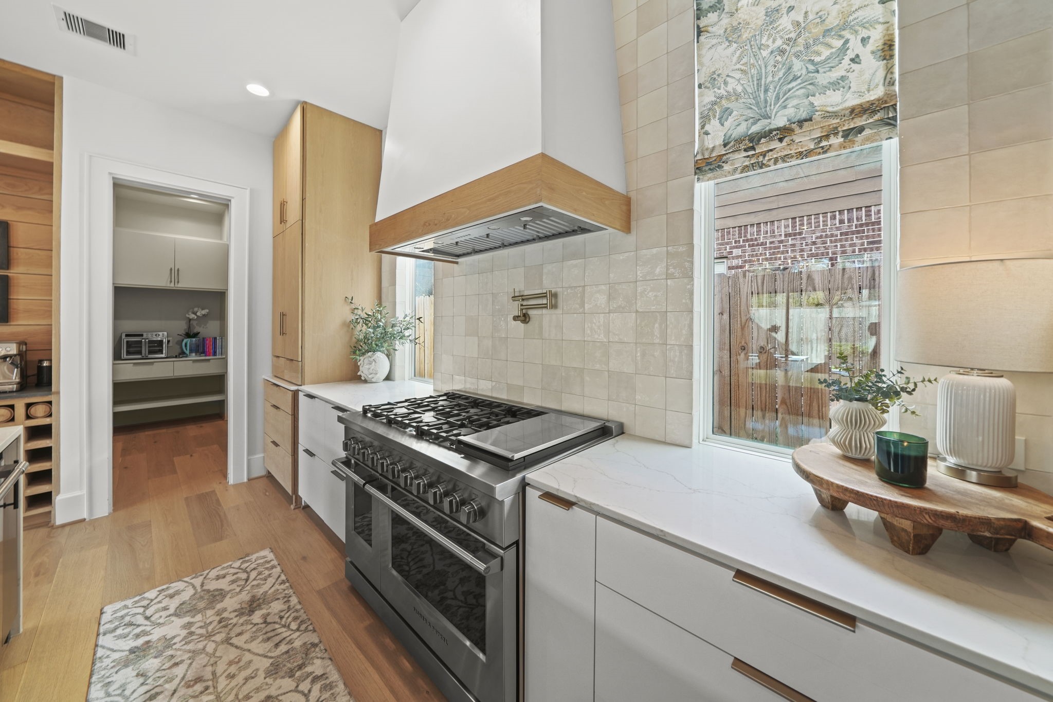 Gorgeous stove/oven and windows provide light into the kitchen!