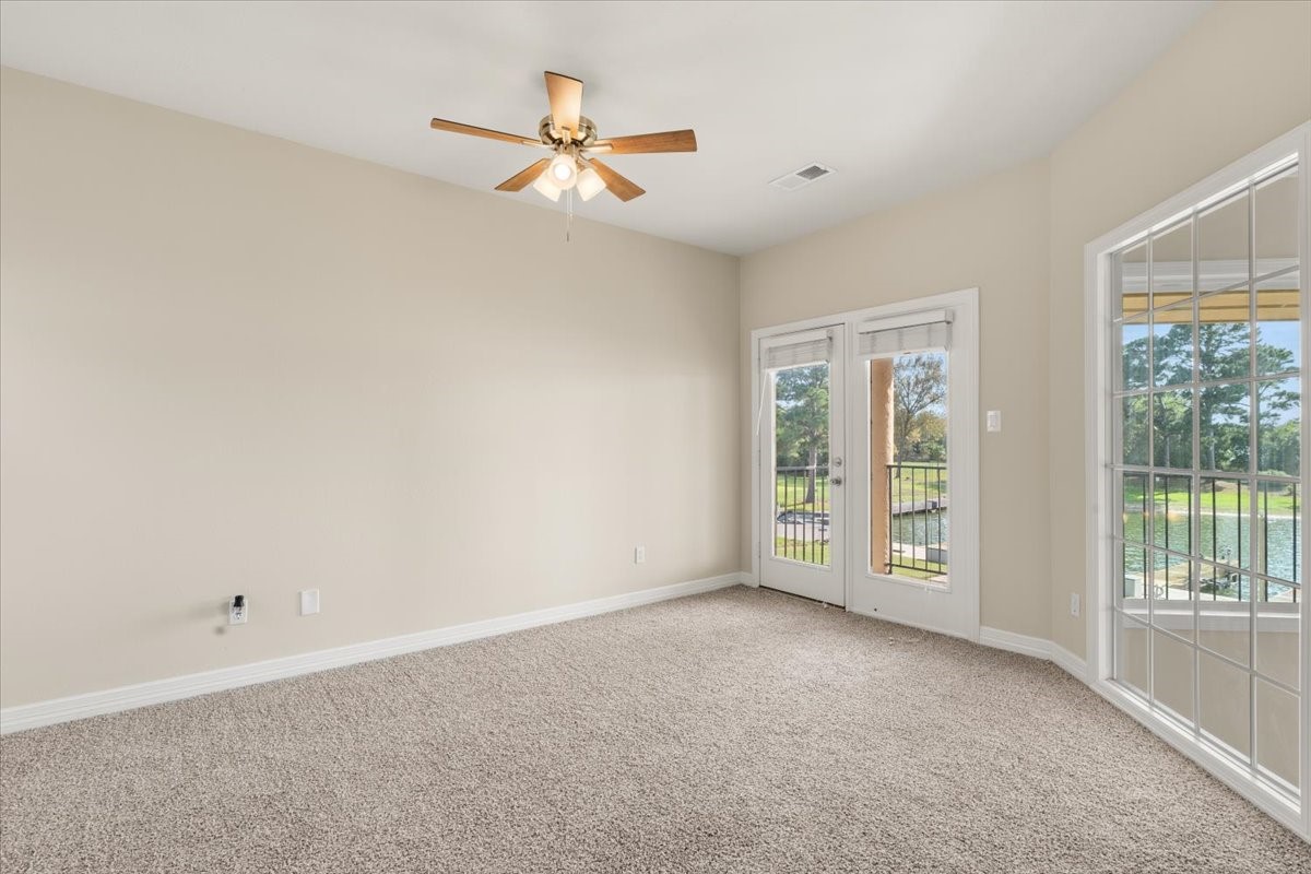 Upstairs bedroom with french doors leading to private covered patio overlooking the lake
