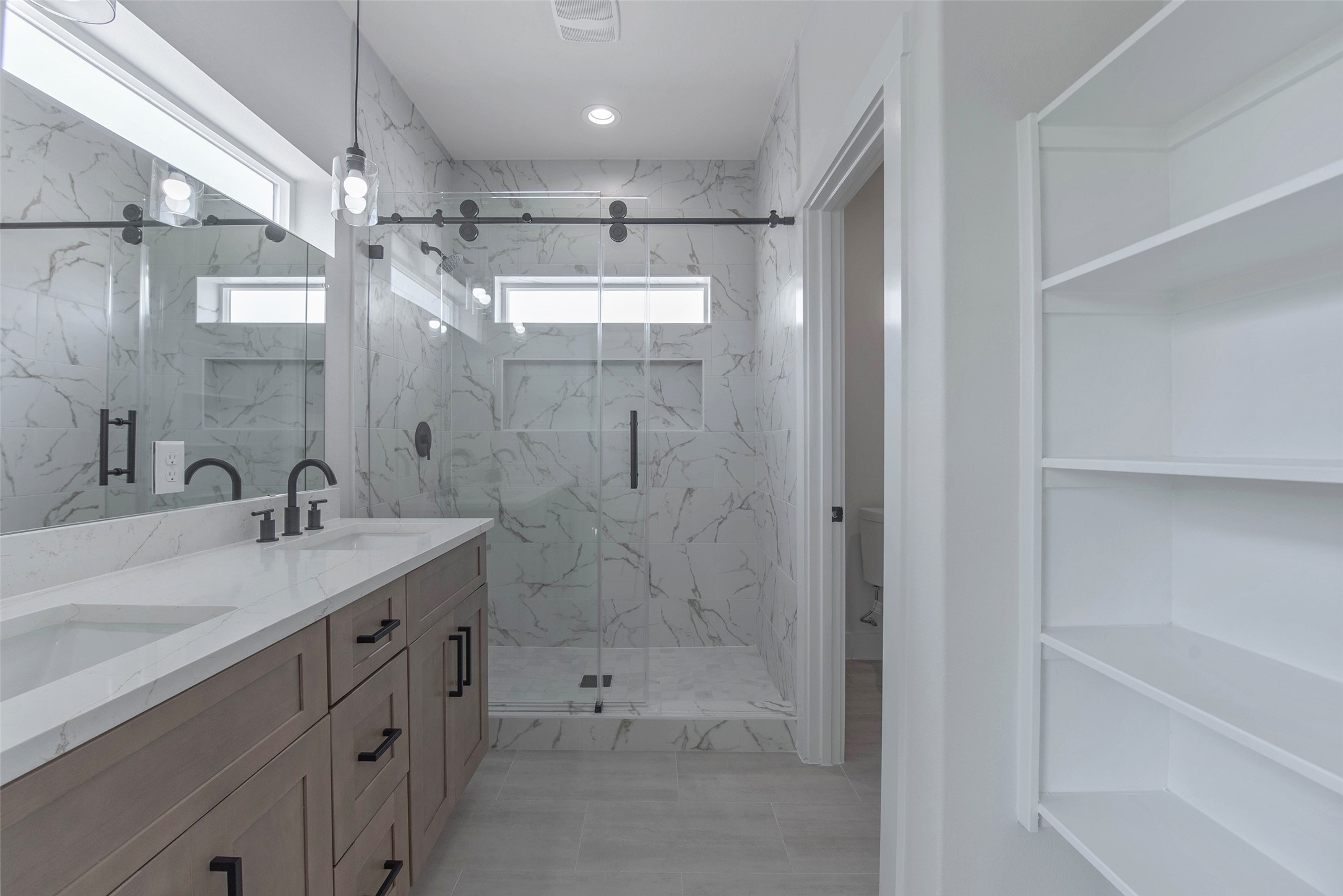 The primary bath offers dual vanities with quartz countertops, a large mirror, a spacious walk-in shower, and ample storage, creating a comfortable and well-appointed retreat. The primary bath offers dual vanities with quartz countertops, a large mirror, a spacious walk-in shower, and ample storage, creating a comfortable and well-appointed retreat.