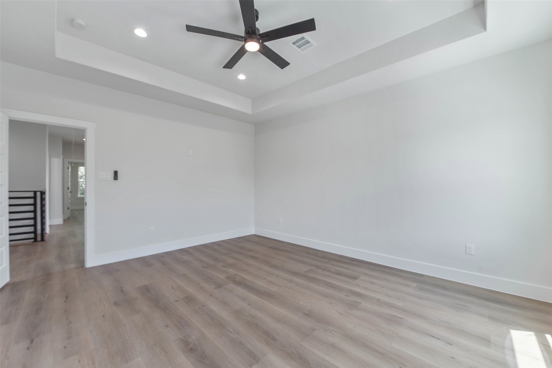 The primary bedroom features a beautifully recessed ceiling, adding depth and architectural interest to the space.