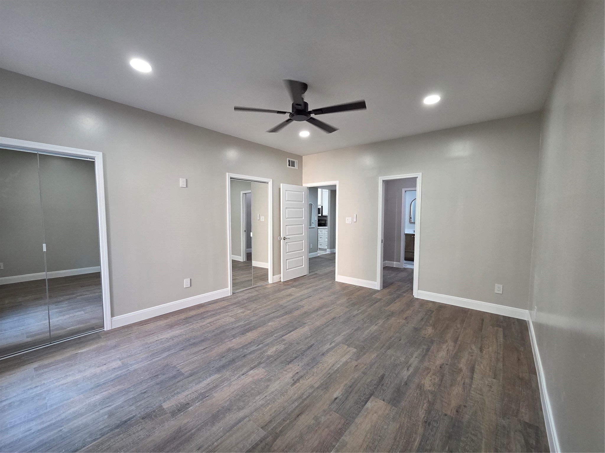 Primary offers dual walkin mirror door closets with recess lighting, celing fan, 5 inch baseboards and usb outlets where needed