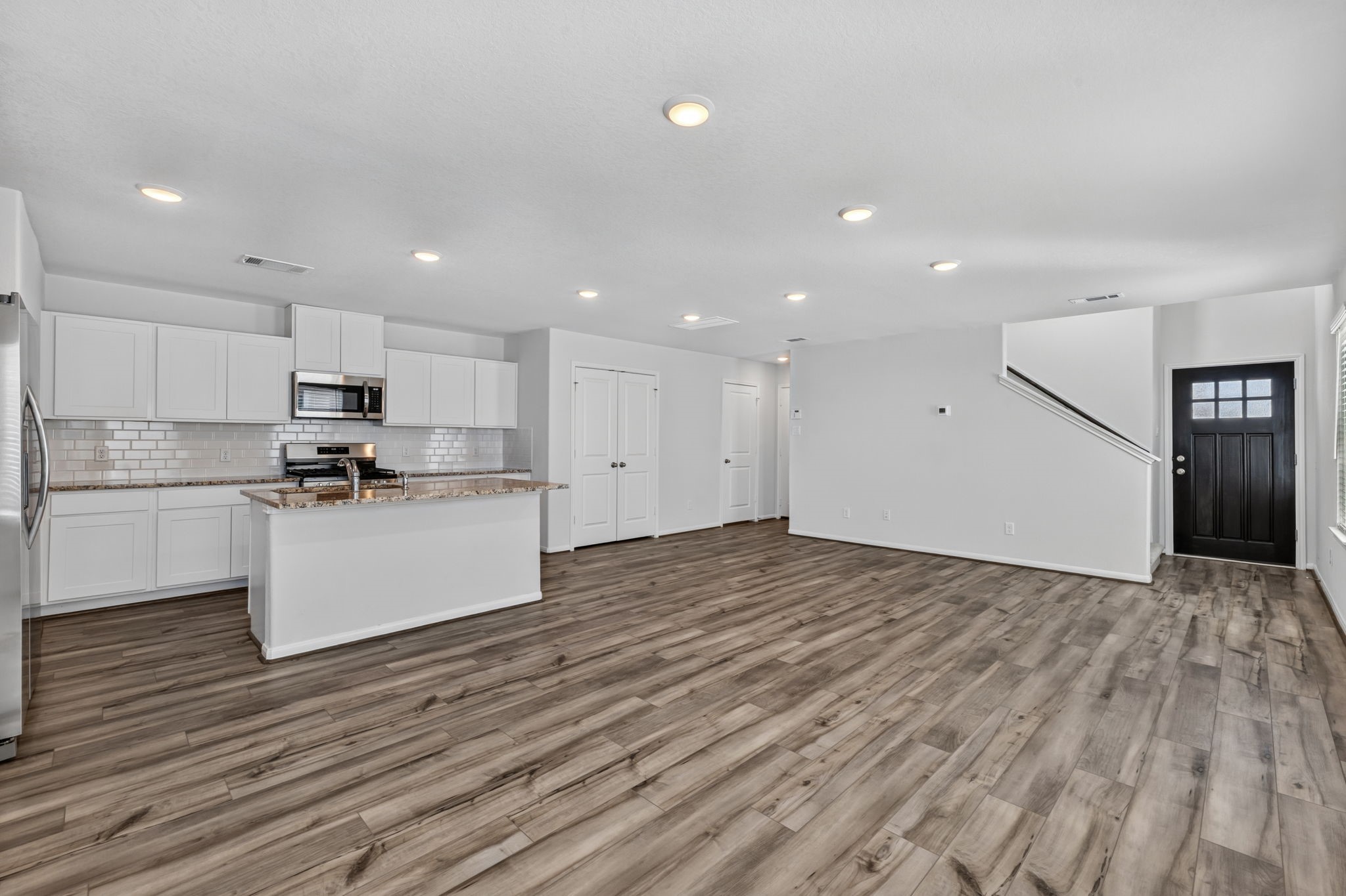 Open concept first floor flows from the front entry into the living and kitchen area with recessed lighting throughout.
