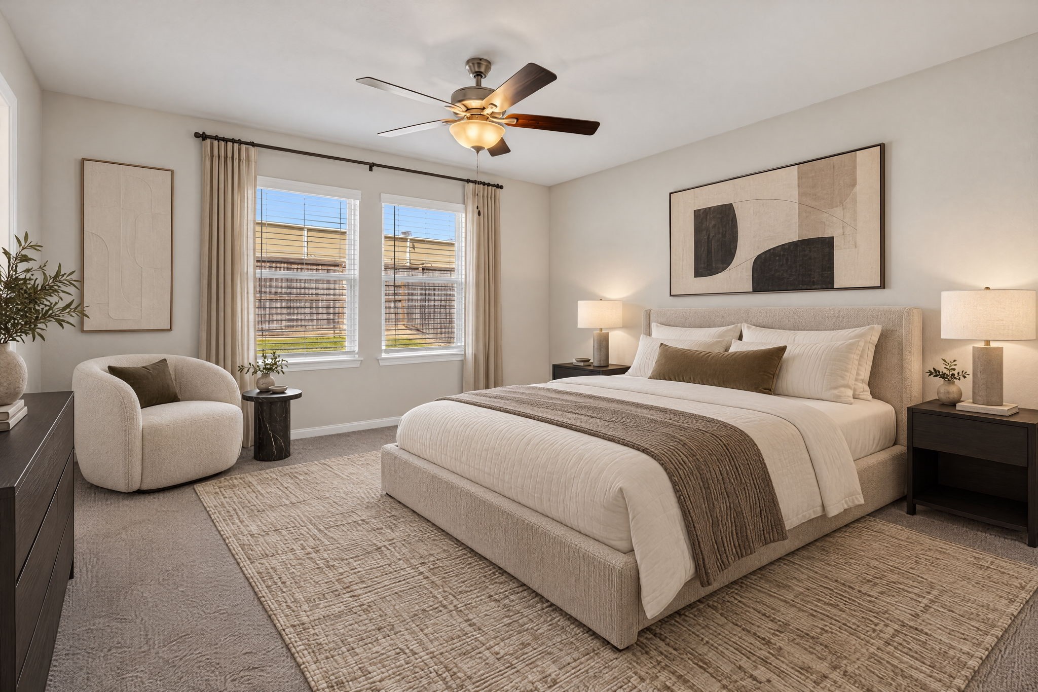 PRIMARY BEDROOM - The primary bedroom has plush carpet, a ceiling fan, and two large windows overlooking the fenced backyard.