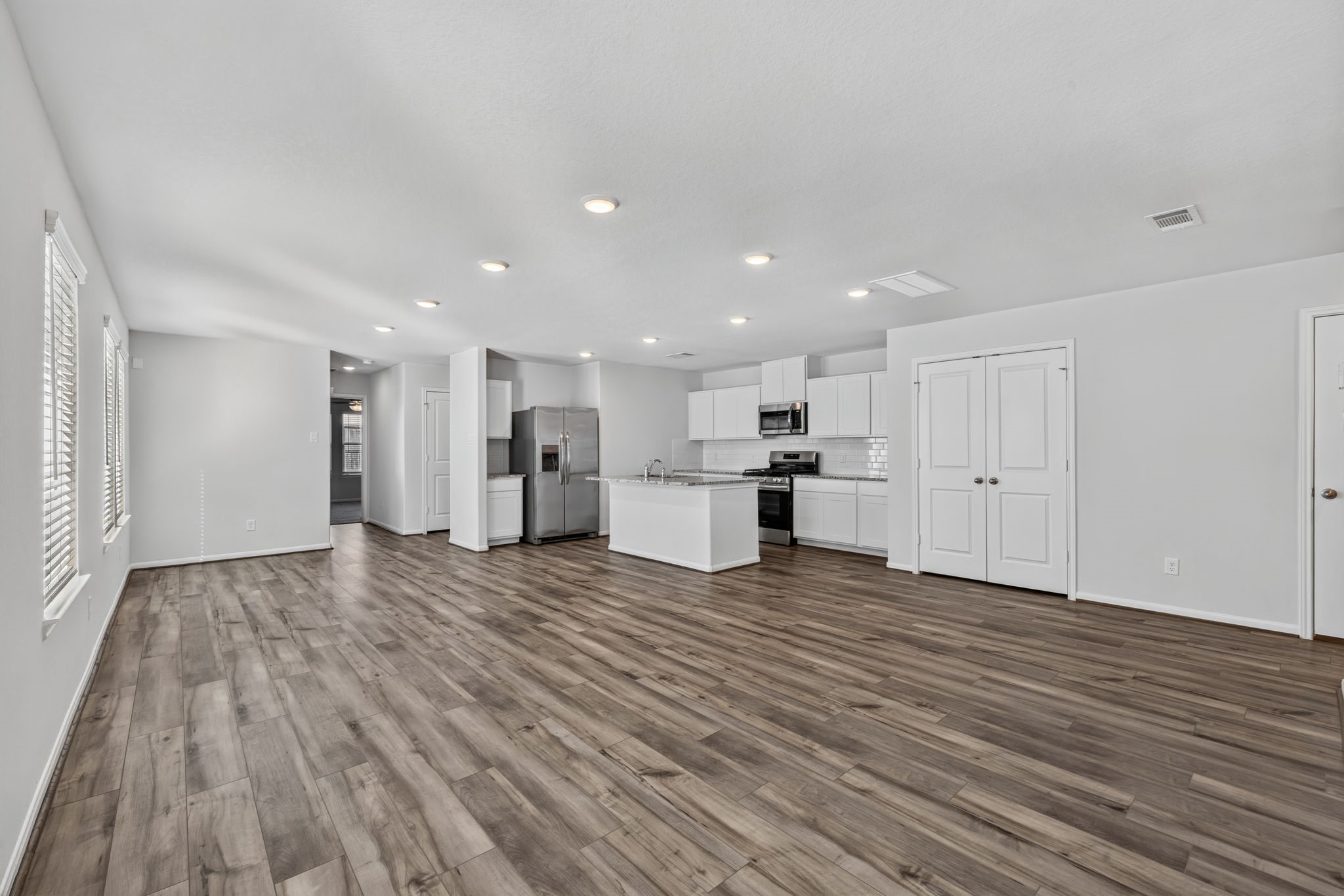 LIVING SPACE - The spacious living area has natural light, and an easy flow into the kitchen with a double door pantry and the hallway to the first-floor bedroom.