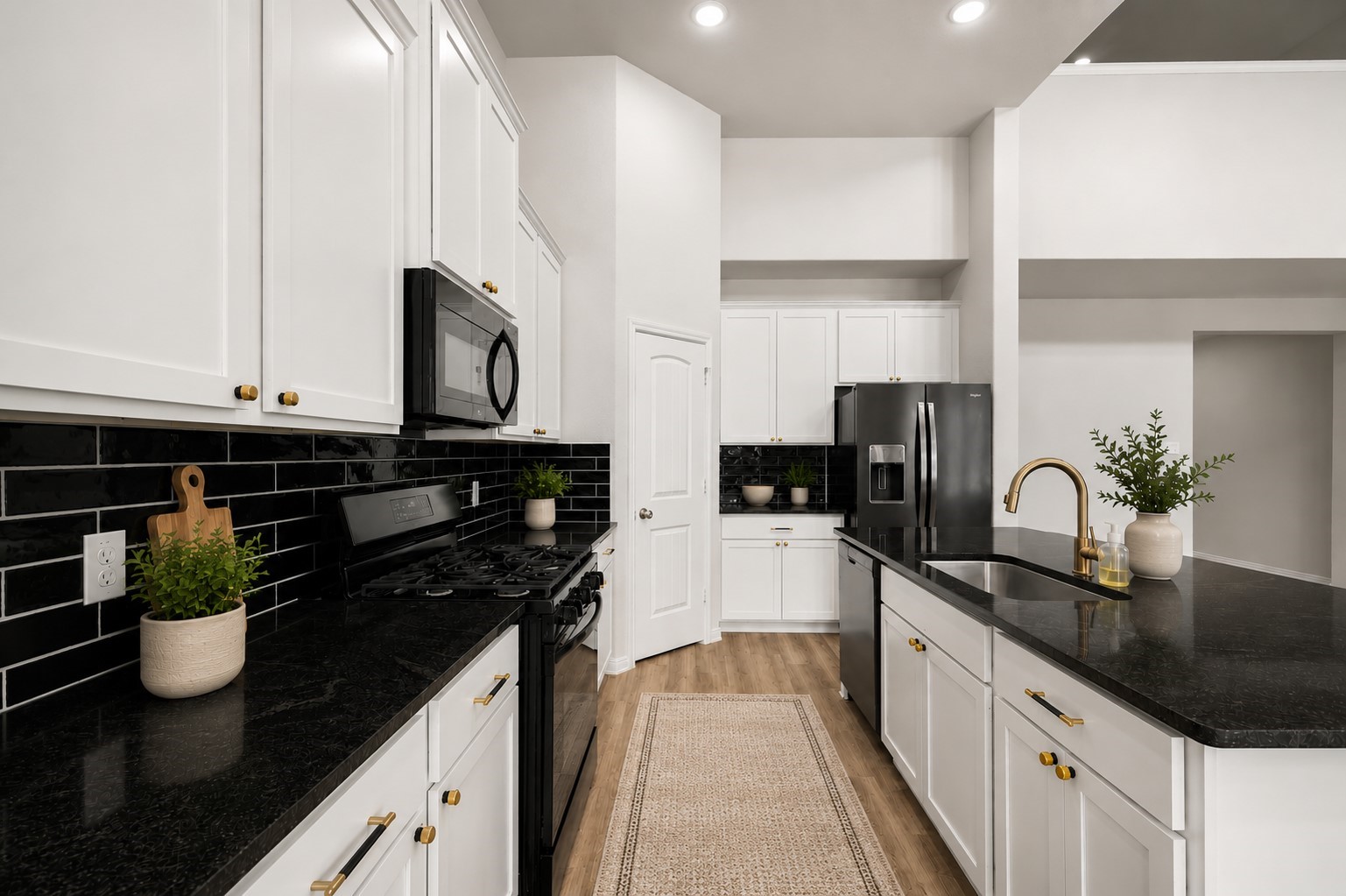 Sleek modern kitchen featuring white cabinetry, black countertops, and a stylish subway tile backsplash, complemented by stainless steel appliances and brass fixtures. Sleek modern kitchen featuring white cabinetry, black countertops, and a stylish subway tile backsplash, complemented by stainless steel appliances and brass fixtures.