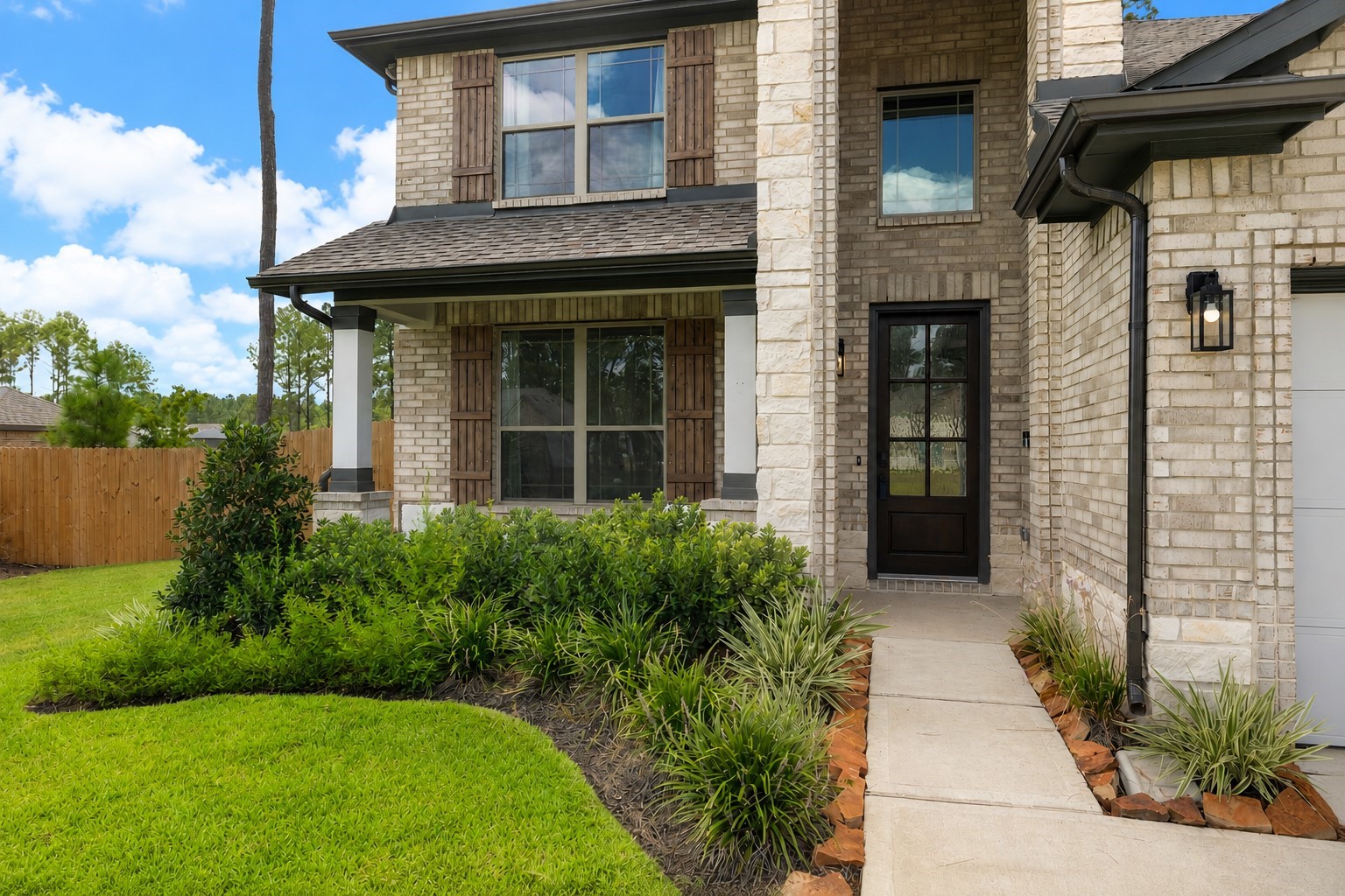 Charming brick exterior with rustic shutters and a welcoming front entrance, complemented by lush landscaping to welcome you home. Charming brick exterior with rustic shutters and a welcoming front entrance, complemented by lush landscaping to welcome you home.