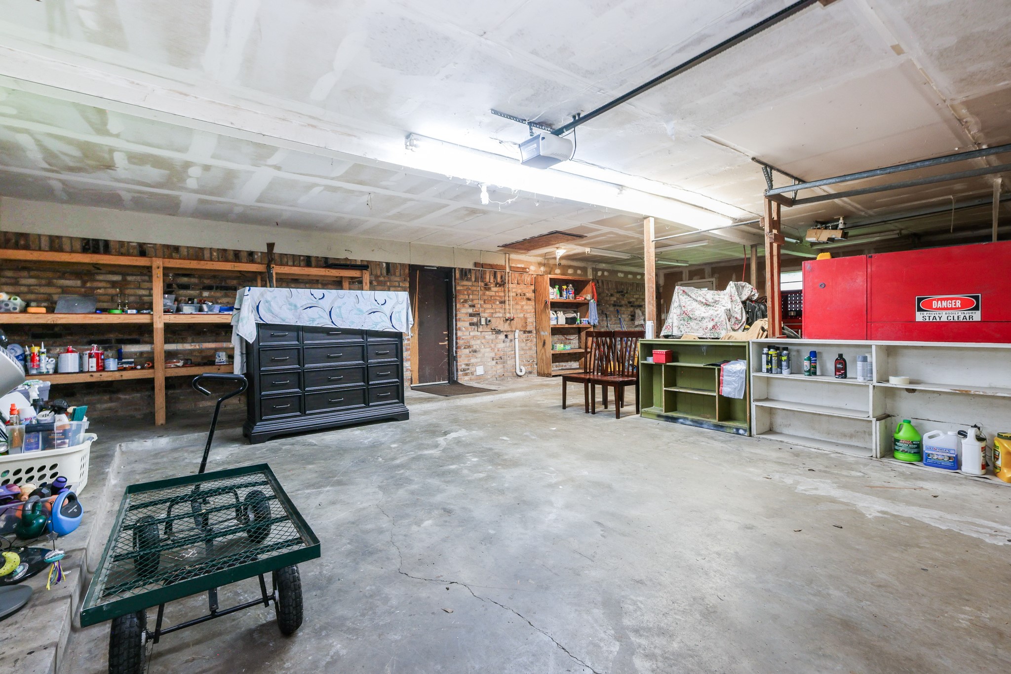 Oversized Garage with built-in heavy duty shelving, door to backyard and washer/dryer connections