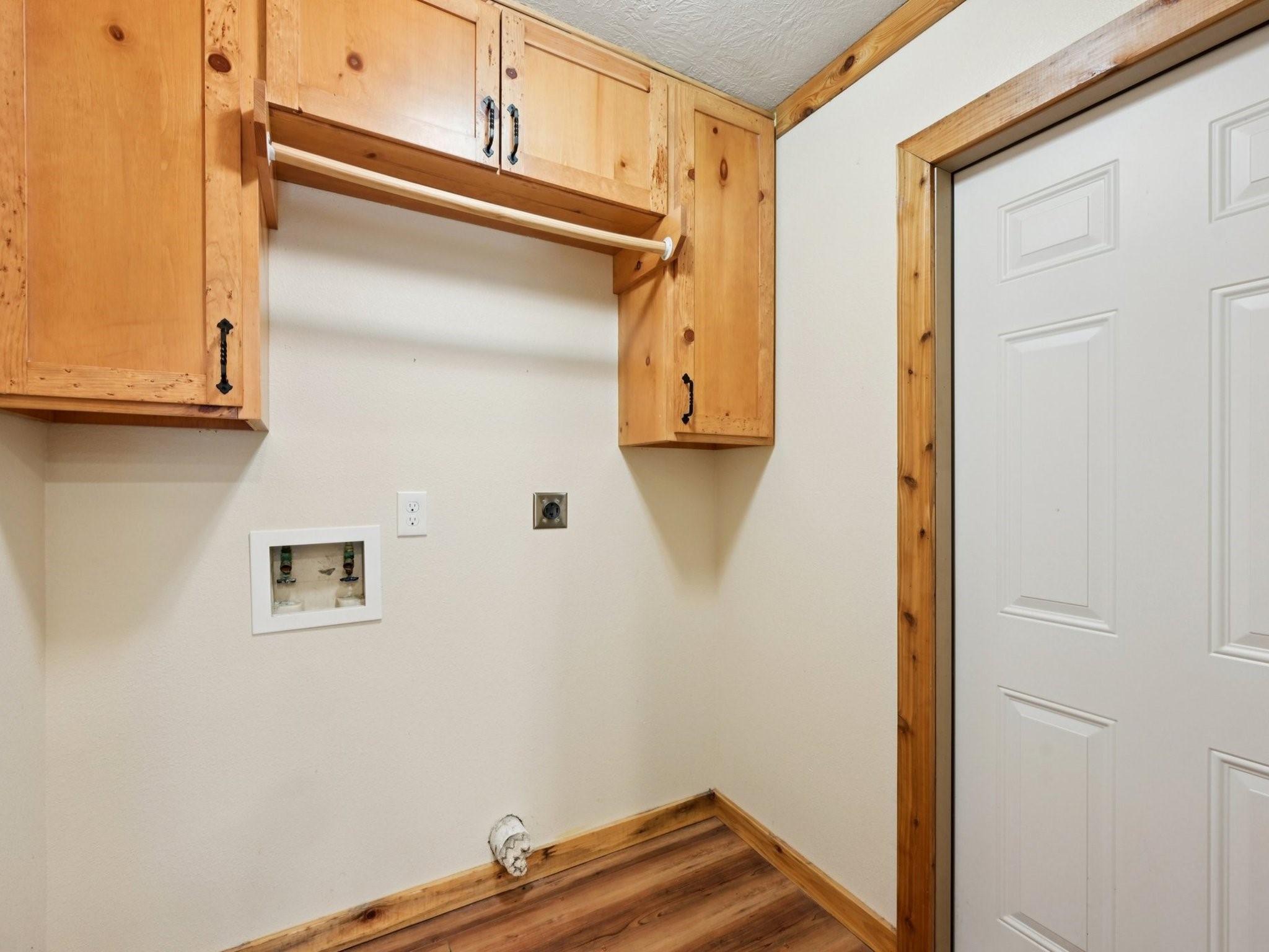 The Laundry room has built-in shelving and a rack for drying clothes. There is even access to the backyard from this room.
