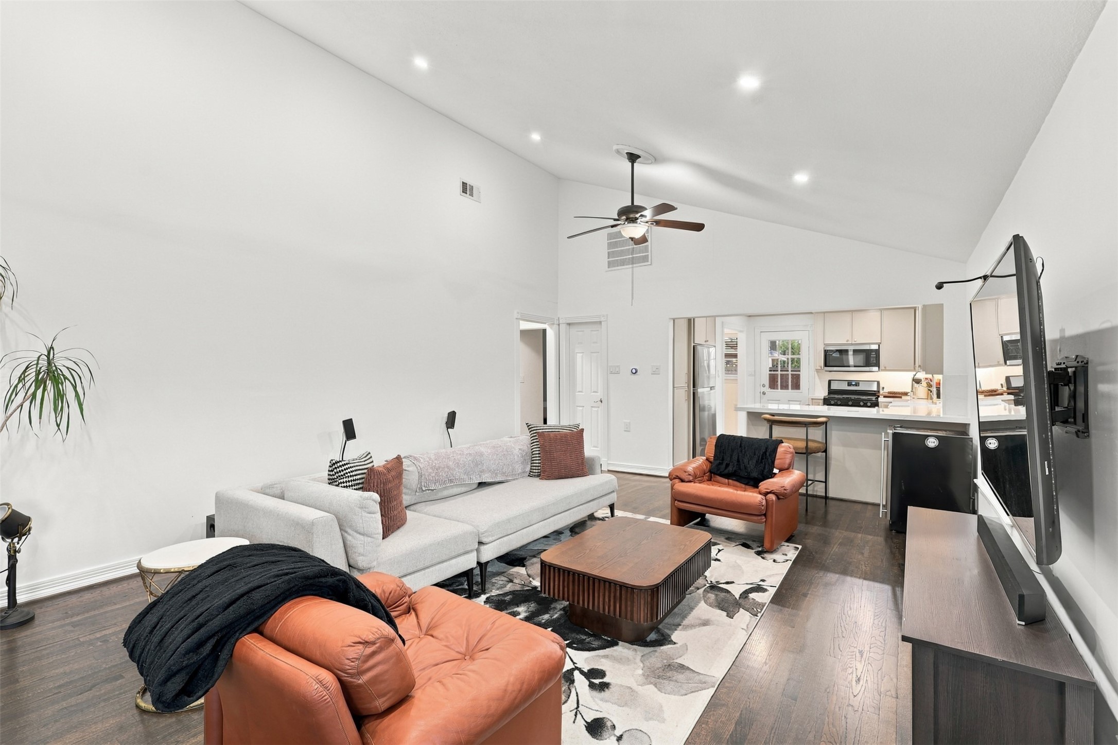 Spacious living area with high ceilings, open layout, and modern finishes, seamlessly connecting to a contemporary kitchen.