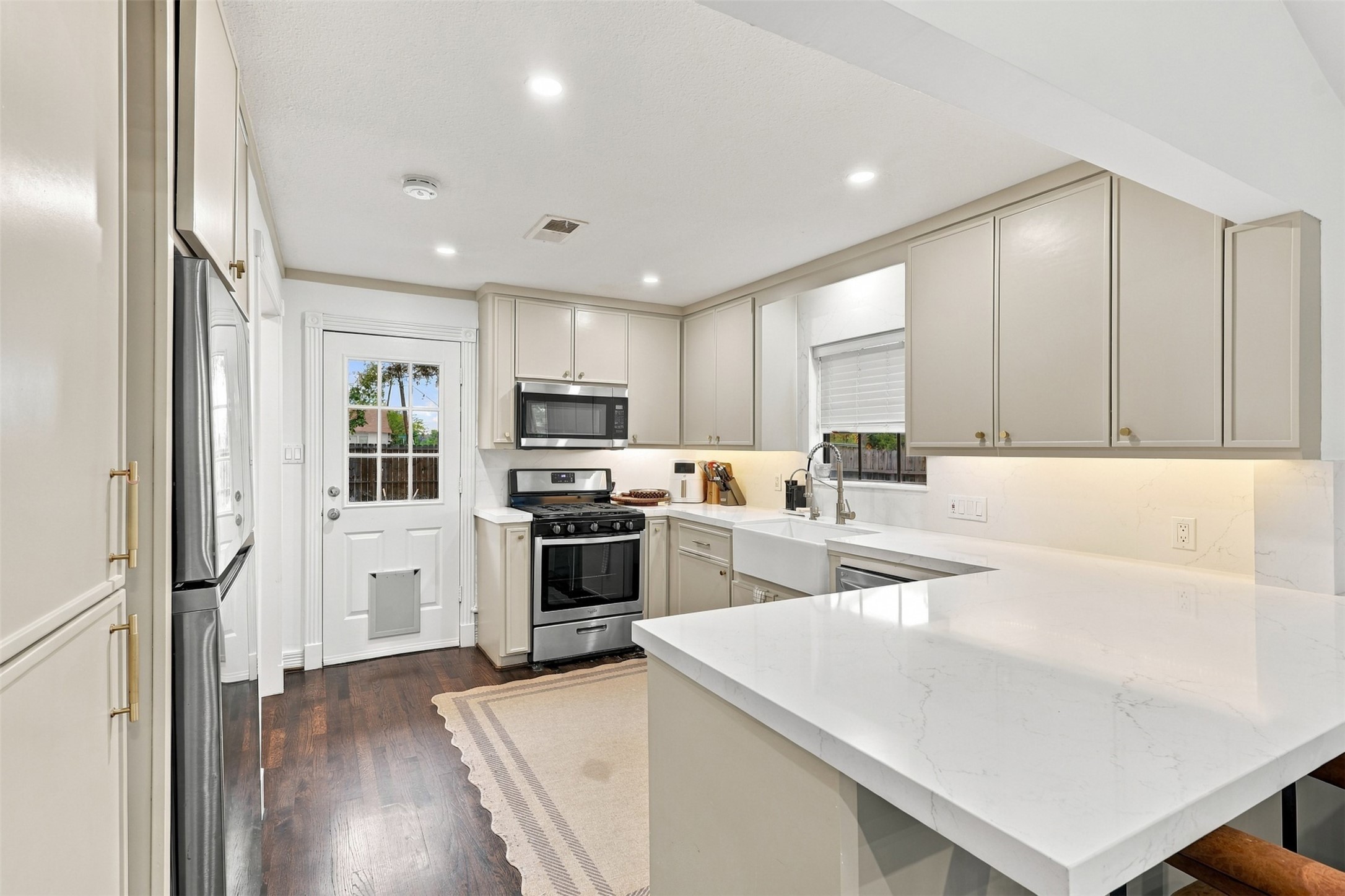 Elegant kitchen with sleek stainless steel appliances, pristine quartz countertops, and ample cabinetry, offering a modern and functional space for culinary endeavors.