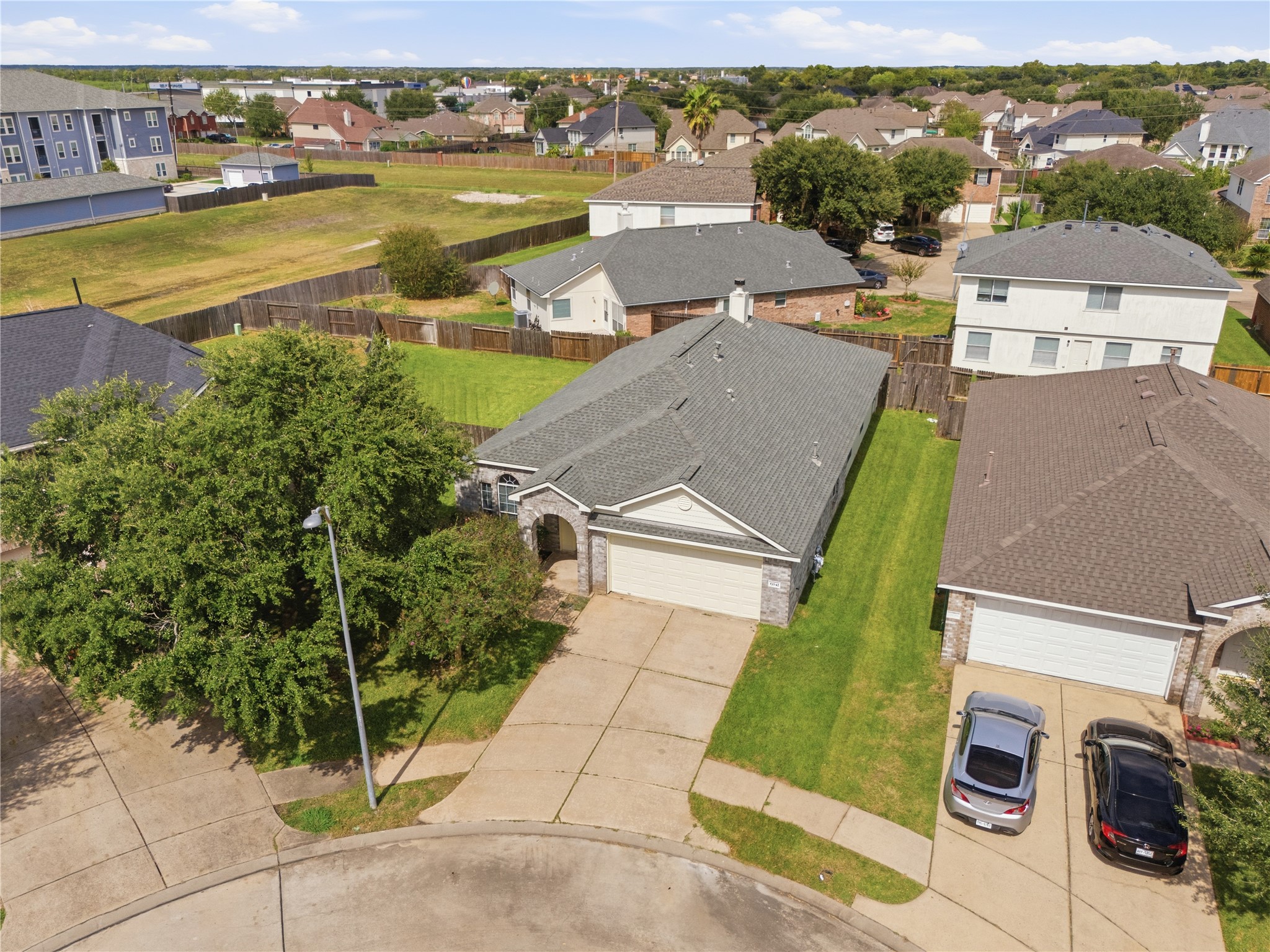 Overhead view showcasing the home's beautiful curb appeal, mature shade tree, and well-maintained lot.