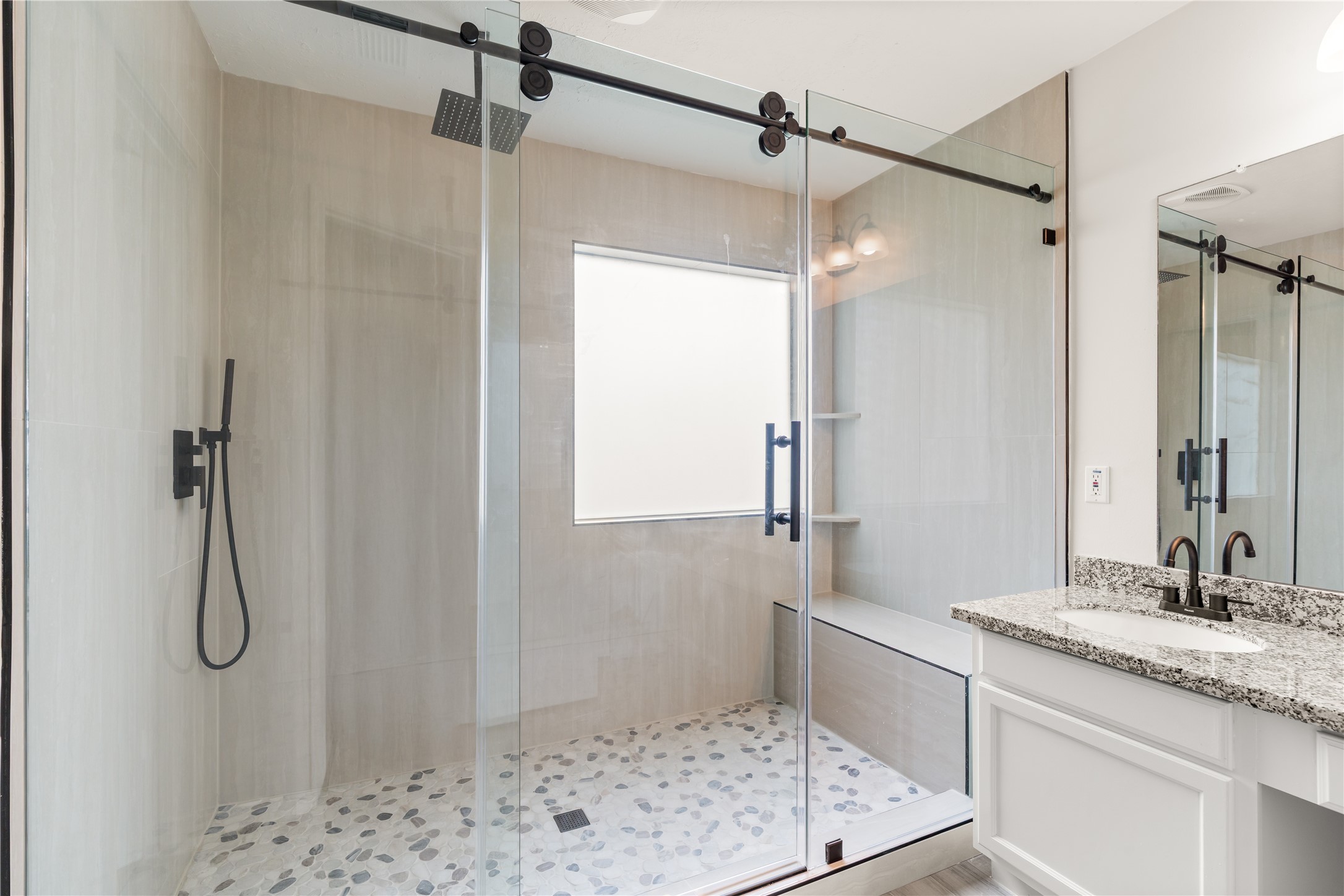 Frameless glass shower and elegant upgrades create a spa-like retreat in the primary bath.