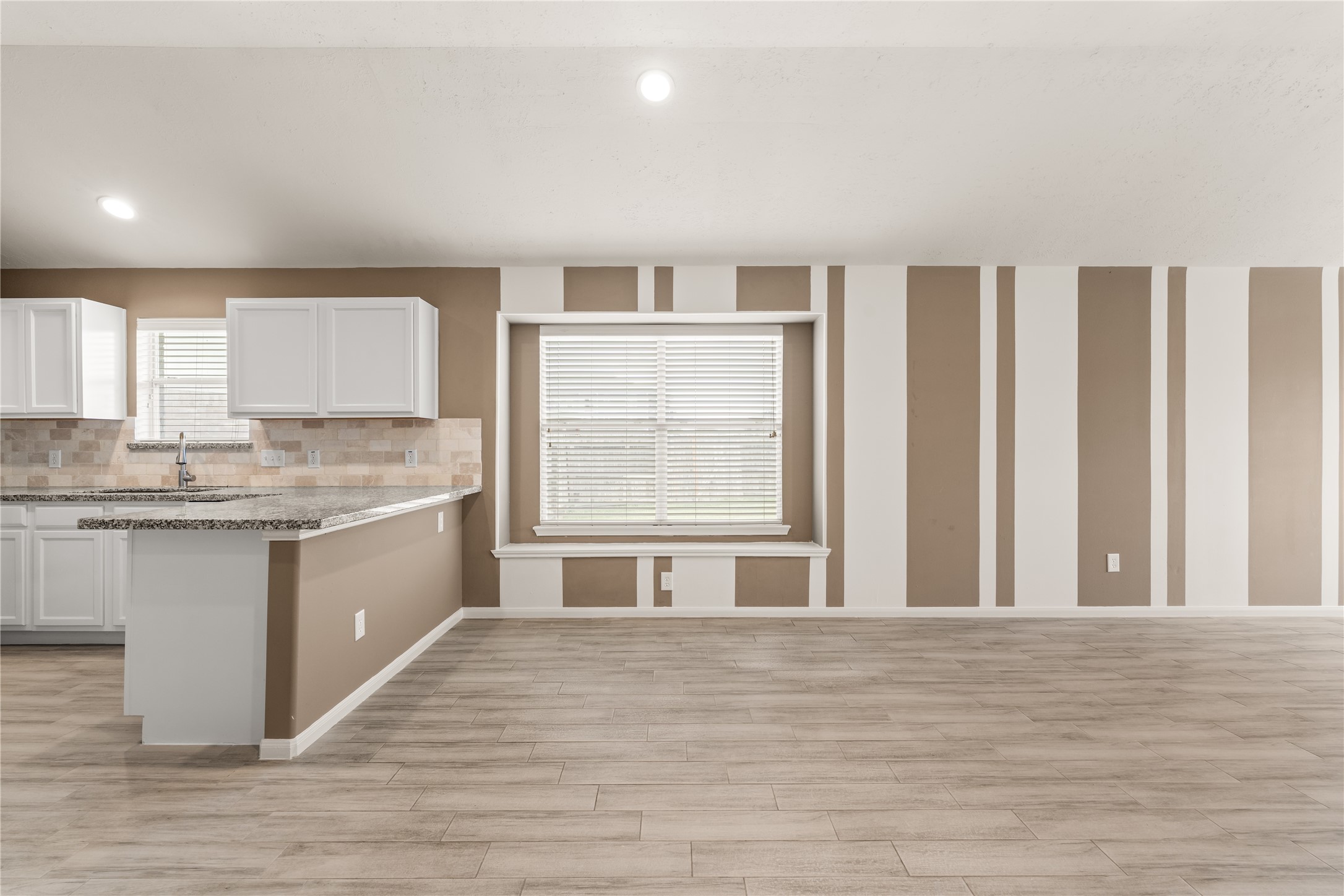 Spacious breakfast area with a charming window seat, complemented by a breakfast bar that offers additional seating and gathering space.