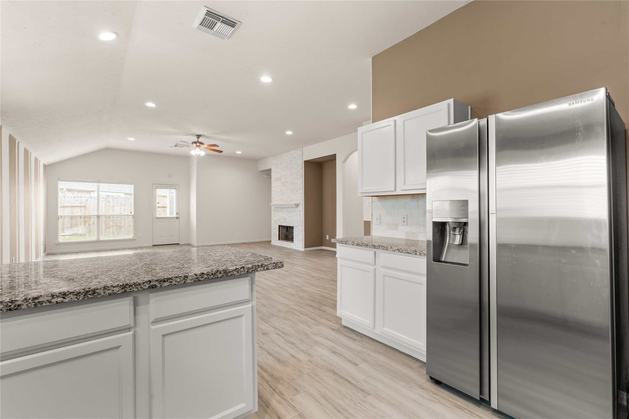 Thoughtful design details shine through, with the fireplace stone coordinating seamlessly with the kitchen backsplash to create a cohesive and inviting living space.