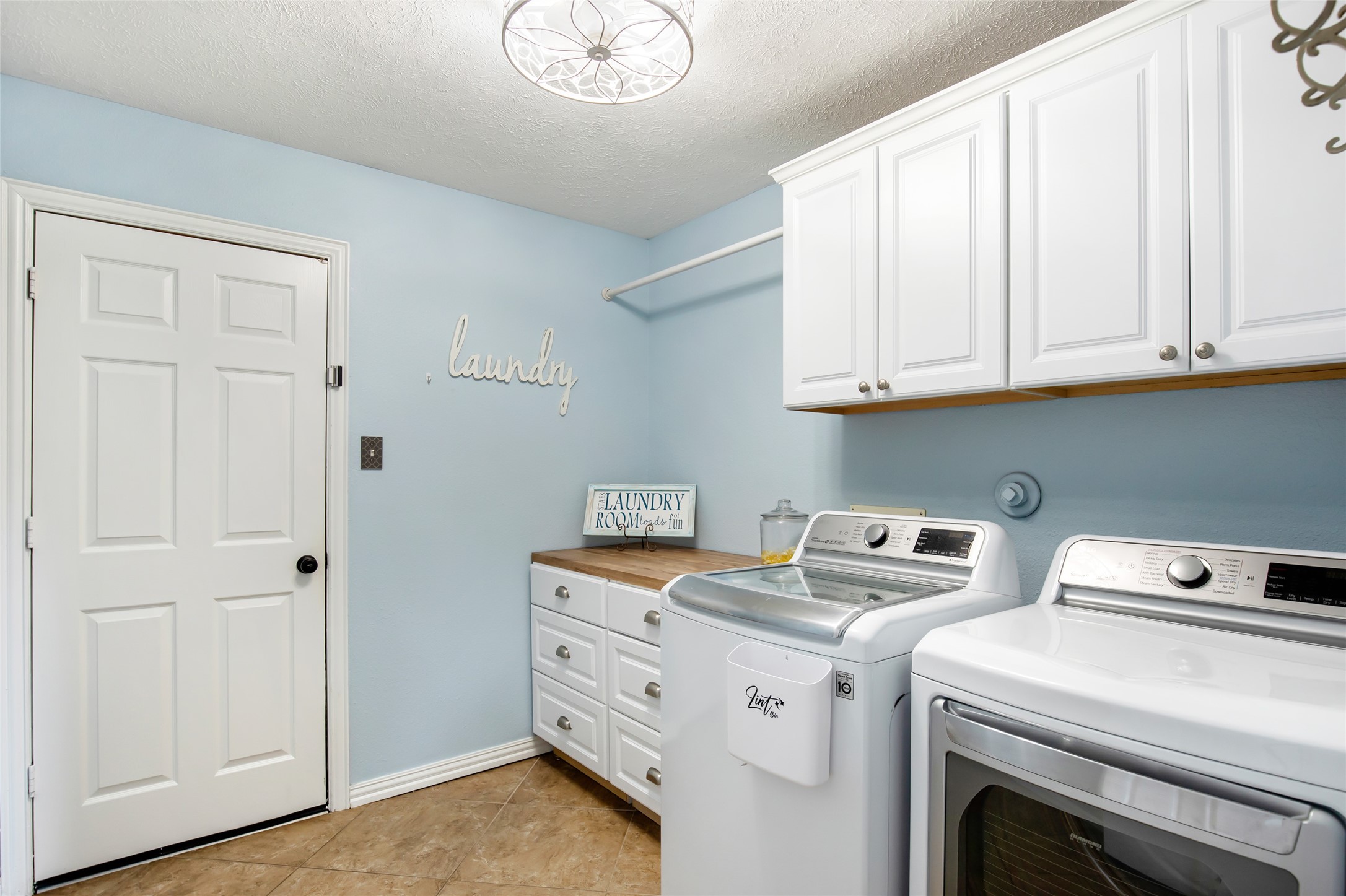 Dedicated utility room with cabinetry, countertop space and room for laundry appliances