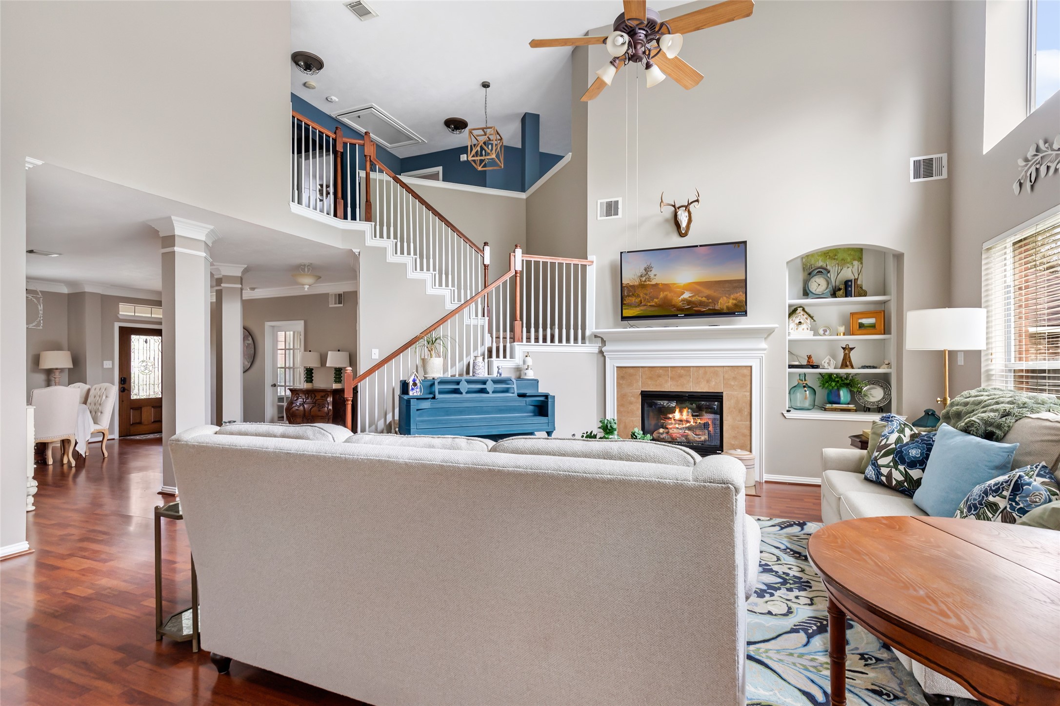 Open-concept living area showcasing the two-story ceiling and open staircase