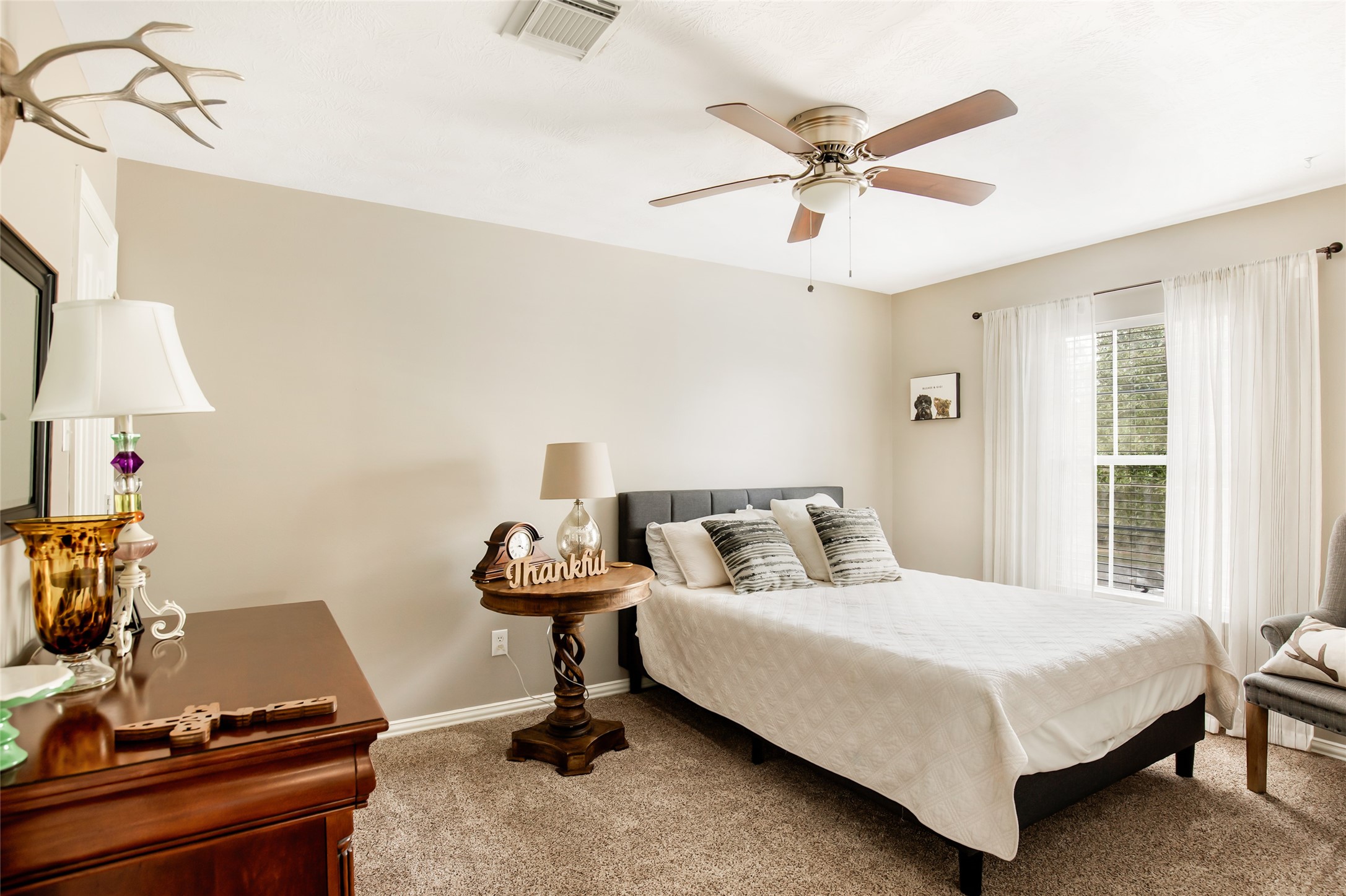 Secondary bedroom with neutral finishes and ceiling fan