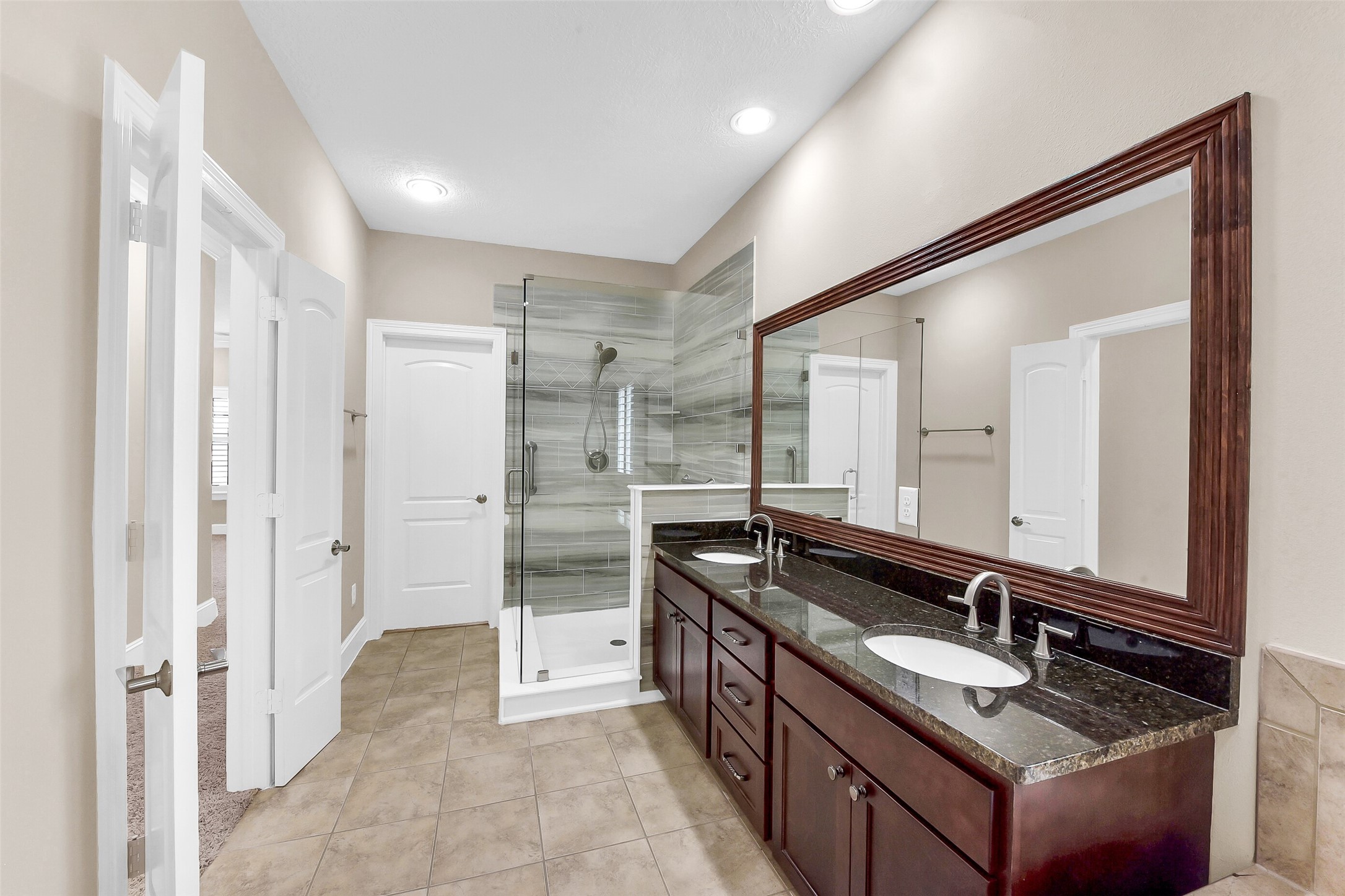 Enjoy the West Shore Custom glass enclosed shower in this large primary bathroom with soaking rub.