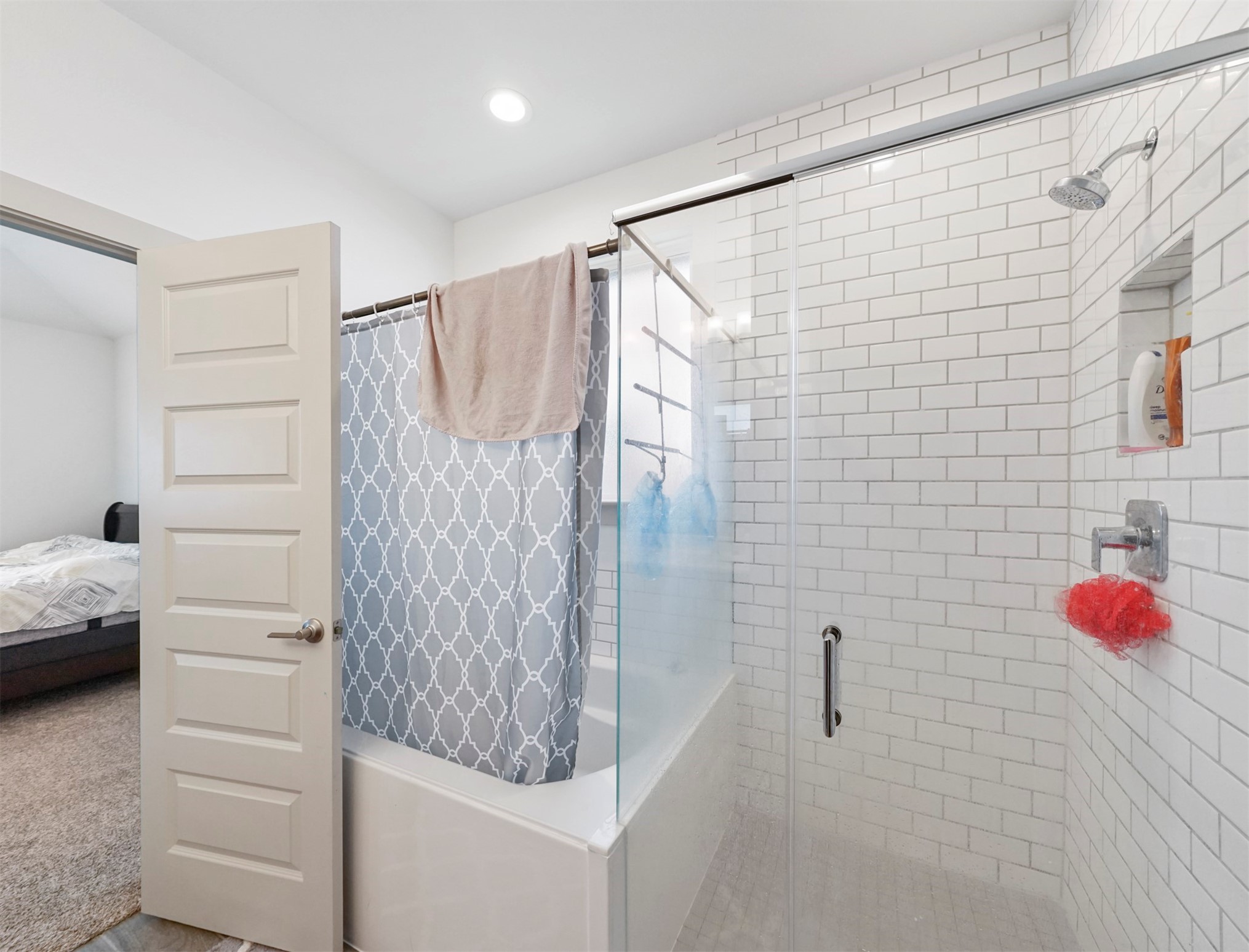 A separate walk-in shower with white subway tile, a glass enclosure, and a built-in niche sits beside a soaking tub.