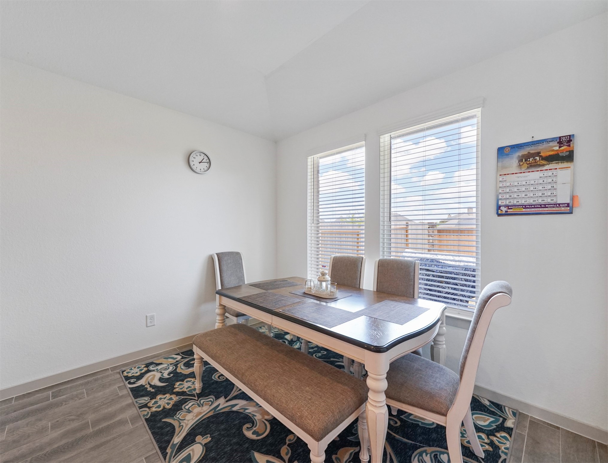 The dining area sits just off the kitchen, with a pair of windows overlooking the backyard.