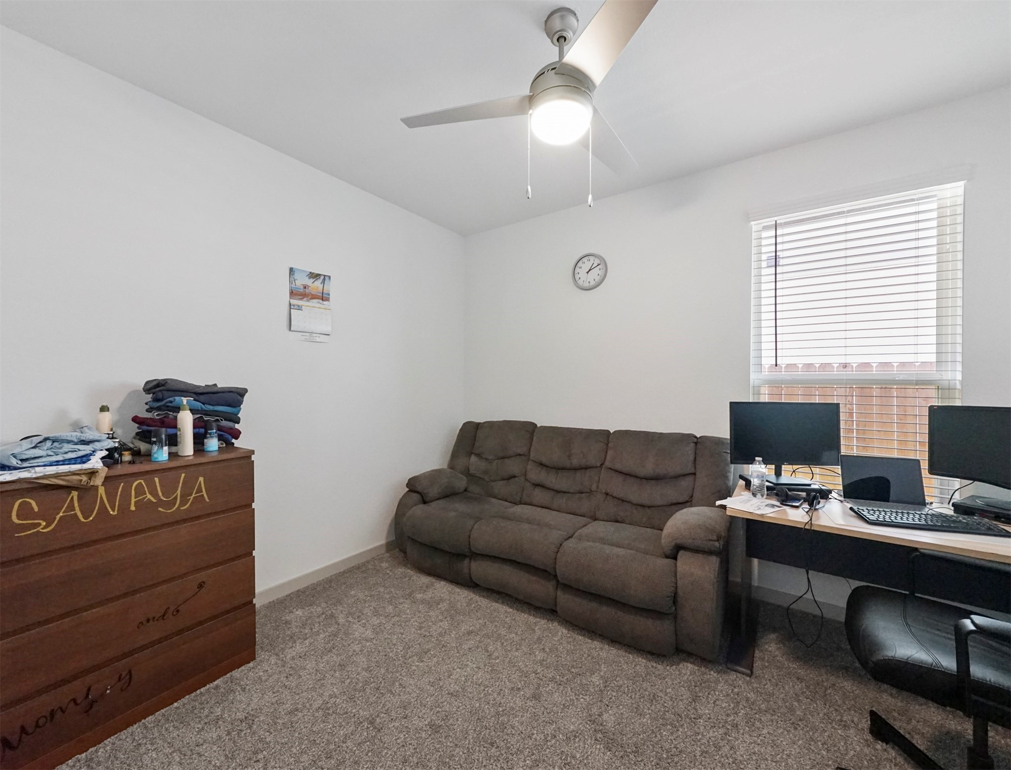 This comfortable secondary bedroom offers plush carpet, a ceiling fan with light, and a generous window that brings in soft natural light.