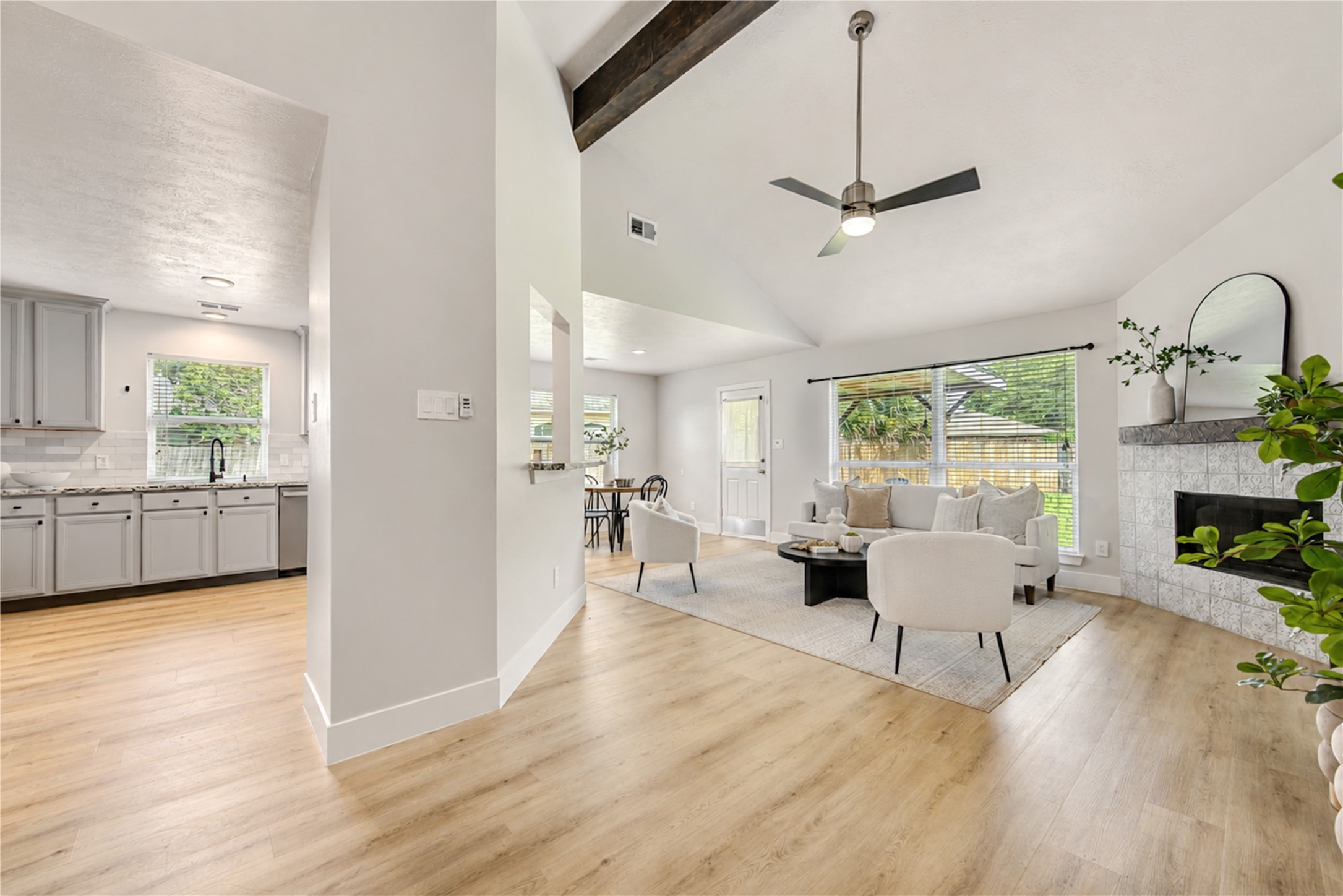 Wooden beam at ceiling and updated fireplace style adds to modern barn house look