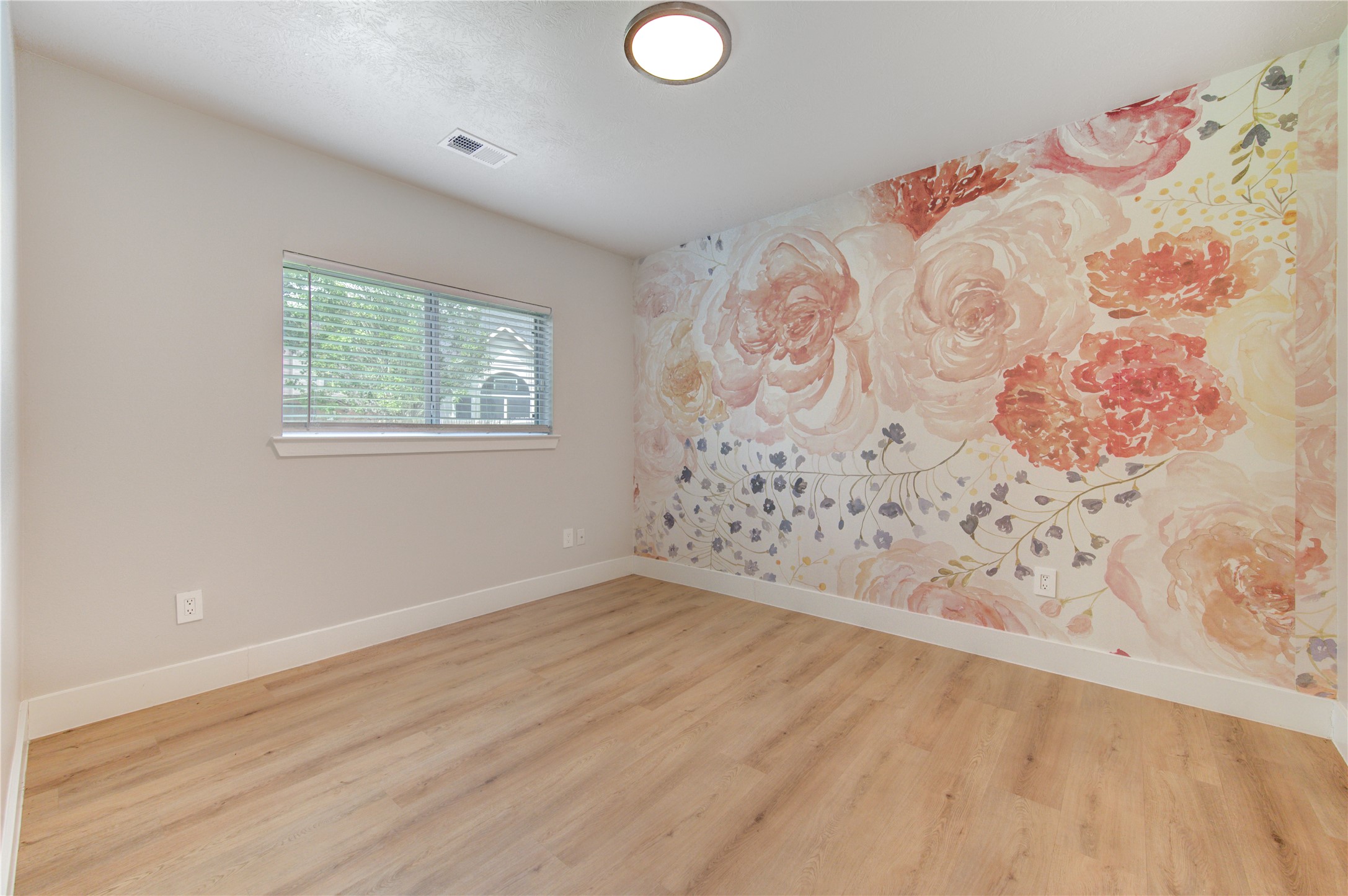 One of four spacious bedrooms, this versatile room is ideal for a guest bedroom, nursery, home office with updated luxury vinyl plank flooring and abundant natural light