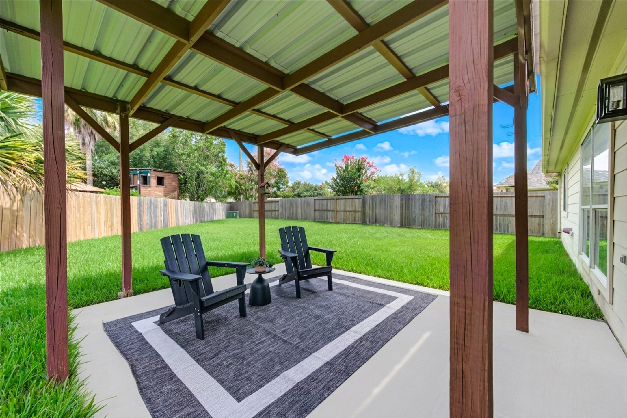Enjoy evening conversations and weekend gatherings beneath the covered patio overlooking the expansive backyard