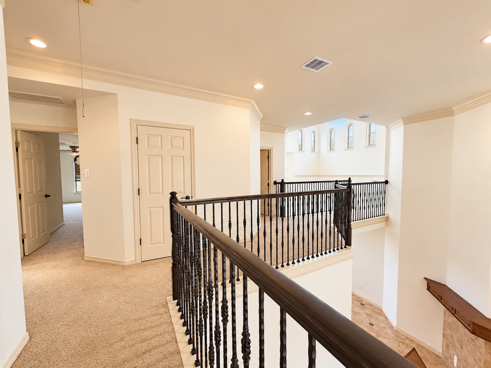Upstairs landing with wrought-iron railing.