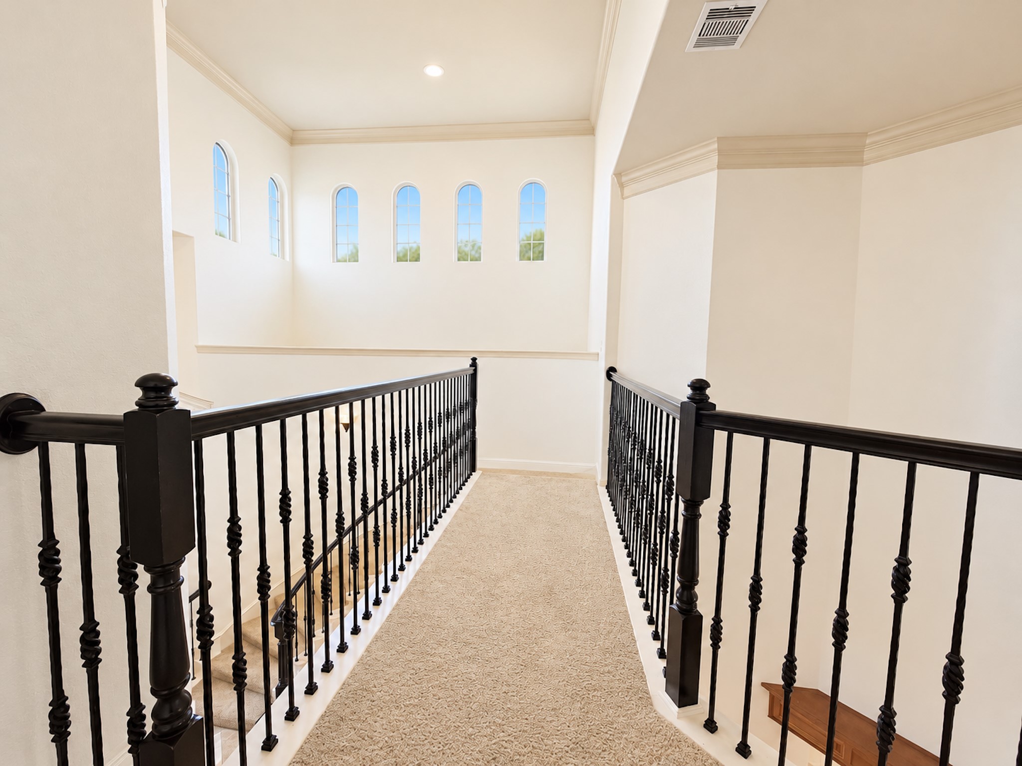 Upstairs walkway with iron railings and clerestory windows.
