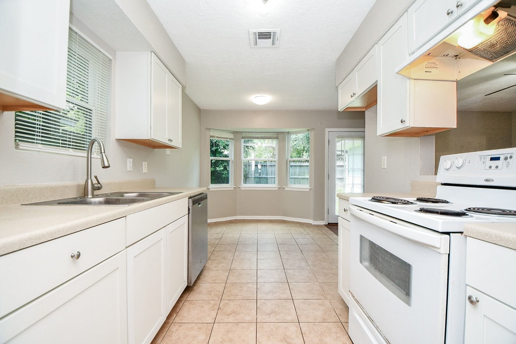 This galley kitchen is plenty wide for two people to work in.  The view to the back through the large windows makes this space feel even larger.