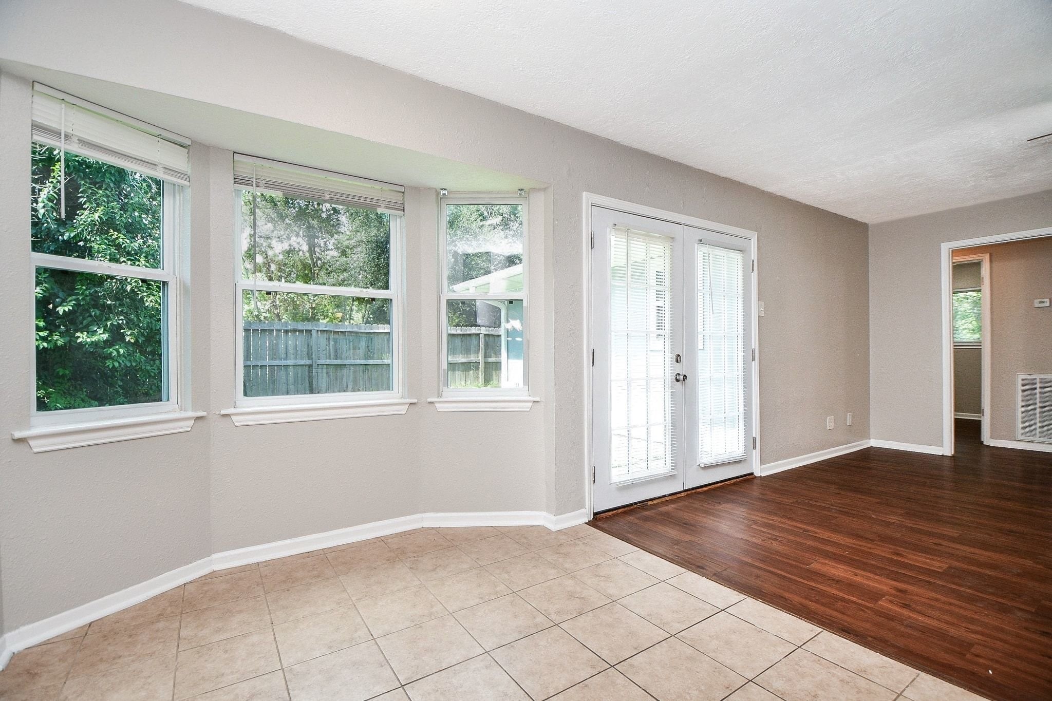 Take pleasure in this beautiful sun-drenched breakfast nook and dining area.  Adjacent French doors open directly to the outdoor patio seamlessly blending indoor and outdoor living.  The space transitions smoothly into the adjoining living room, accented by rich wood color flooring and a modern nuetral color palette throughout.