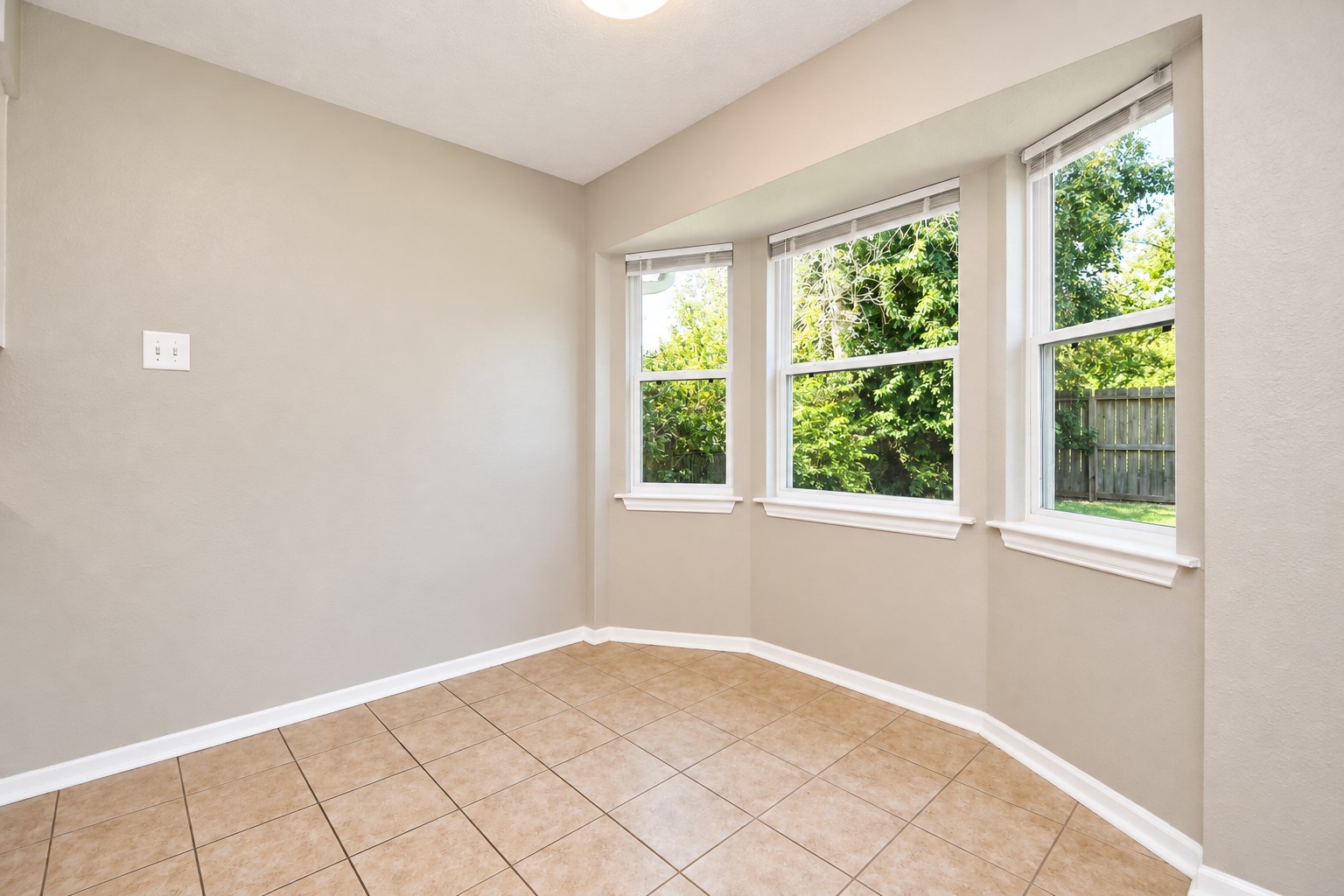 A sun lit breakfast area framed by a charming trio of frames that were upgraded with brand new energy efficient double -pane windows overlooking the backyard.
