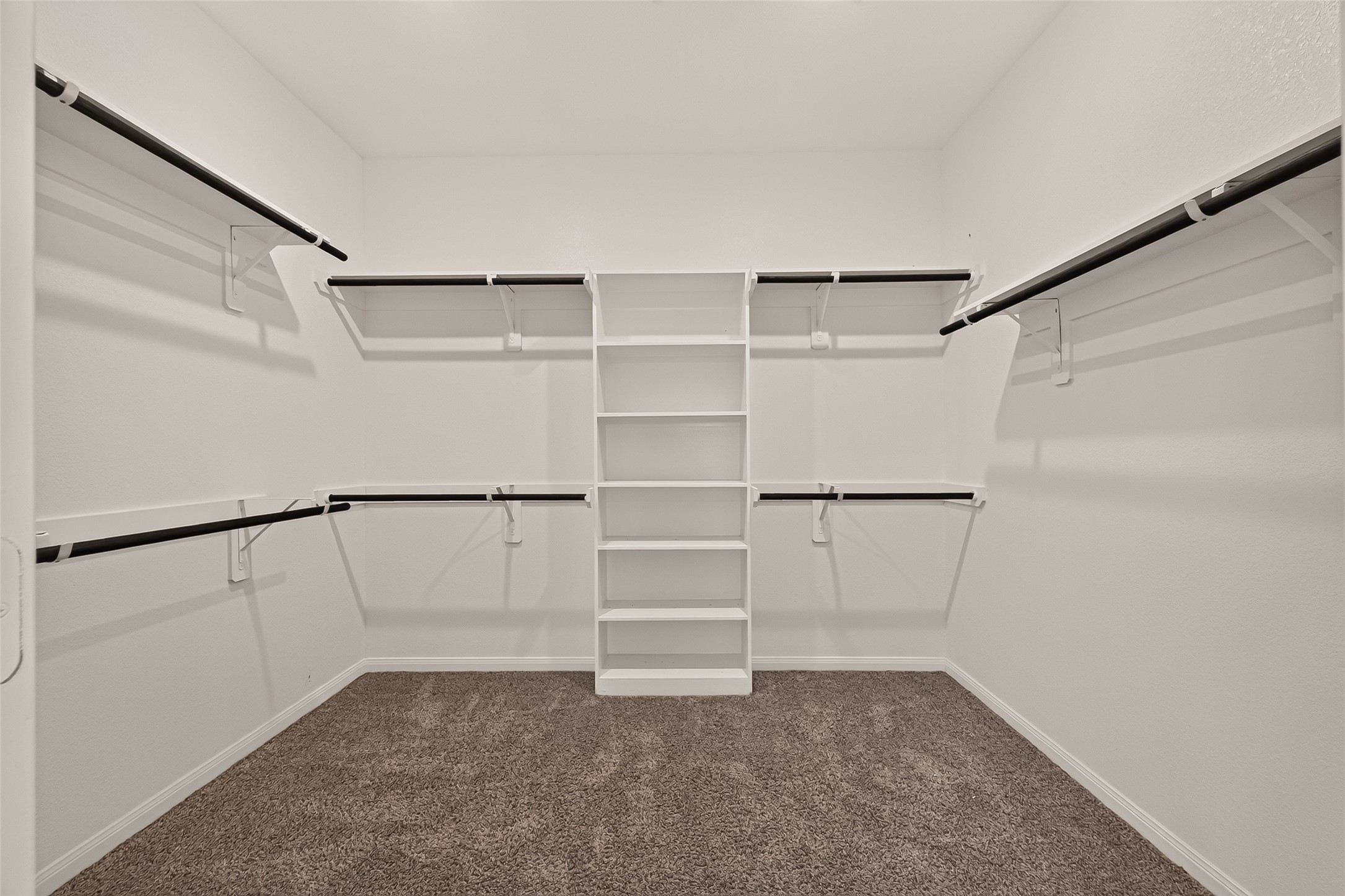 Spacious walk-in closet featuring ample shelving and hanging space for organized storage.