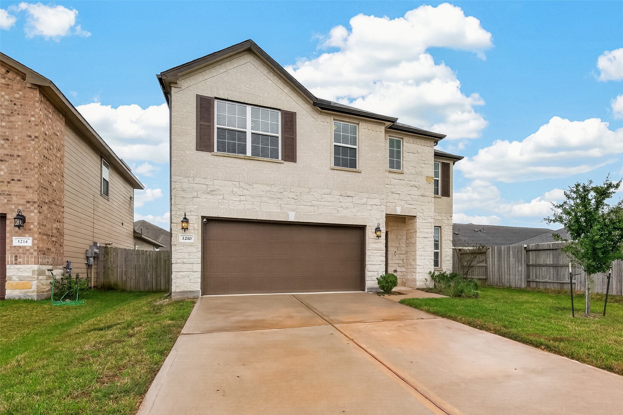 The home features an attractive brick and stone exterior, complemented by decorative shutters that enhance its curb appeal.