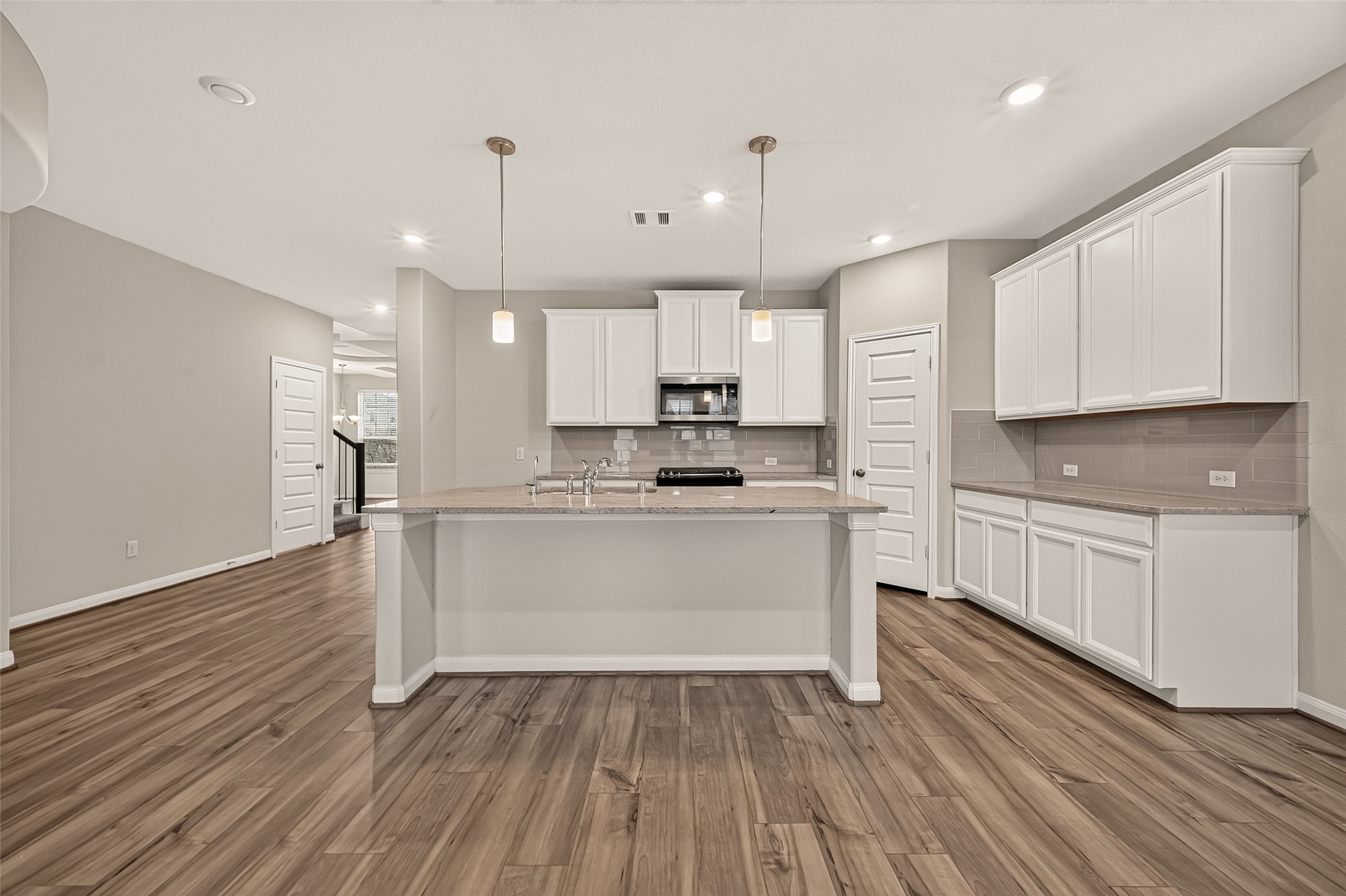 Sleek and modern kitchen featuring elegant granite countertops and a spacious center island for ultimate functionality.