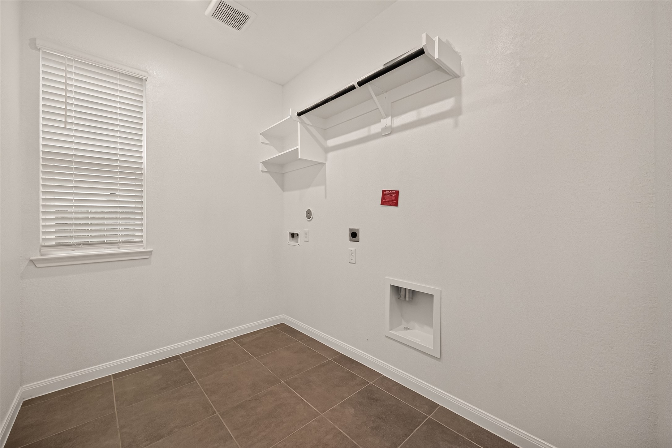 Spacious and bright laundry room with ample storage and natural light for your needs.