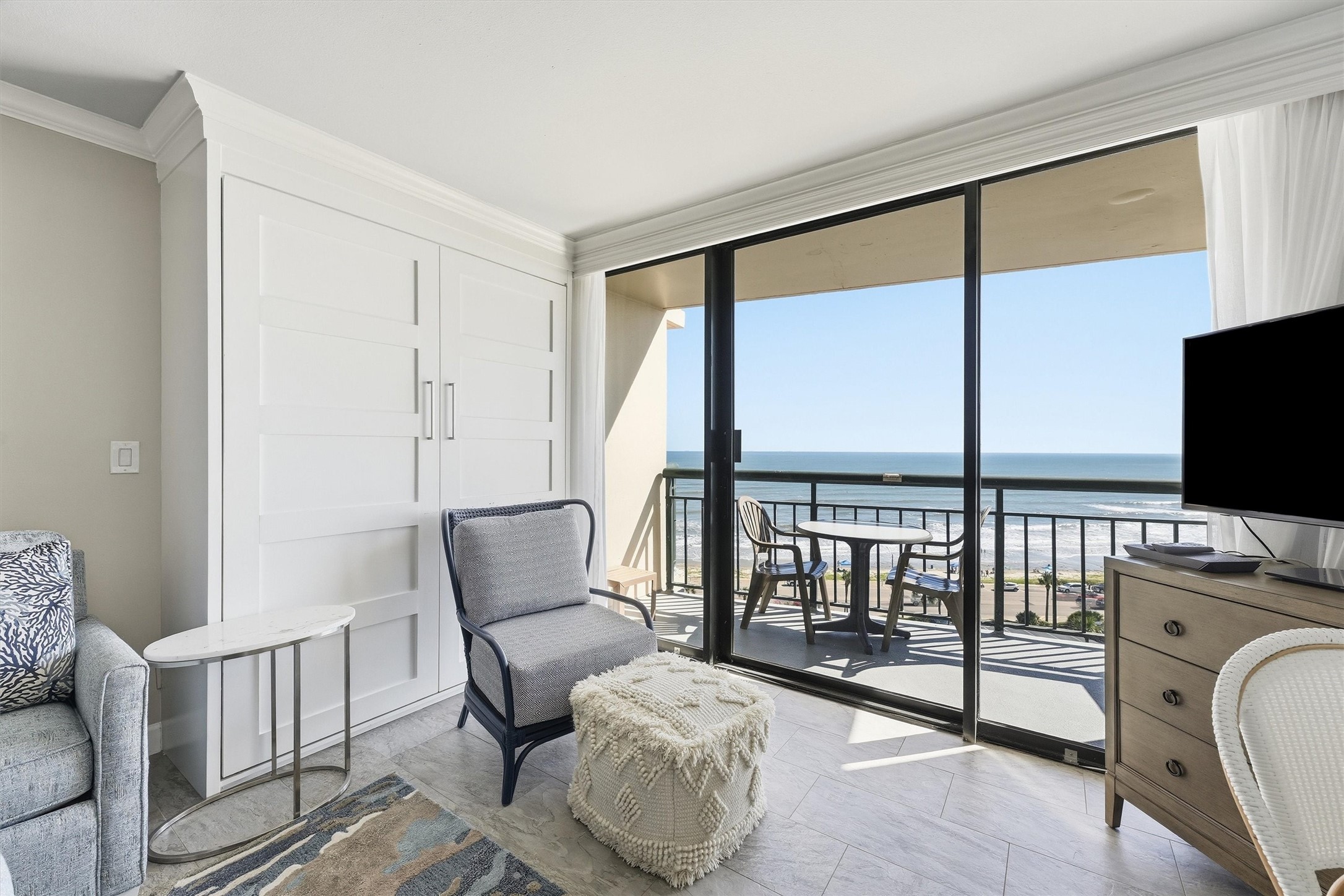 Sliding glass doors welcome abundant sunshine and provide direct access to the covered balcony.