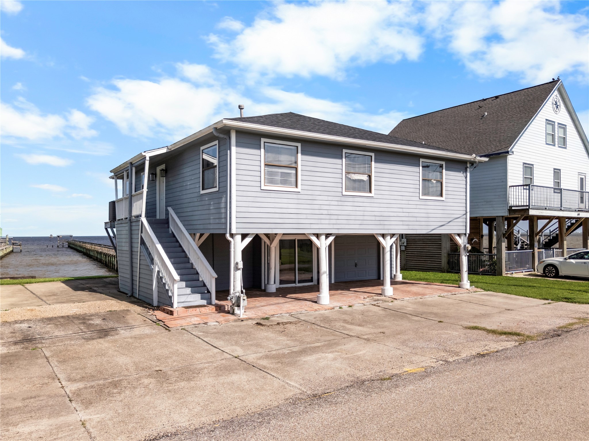 Just steps from the bay, this elevated coastal home pairs timeless waterfront character with the peace of mind of raised construction and uninterrupted coastal views.