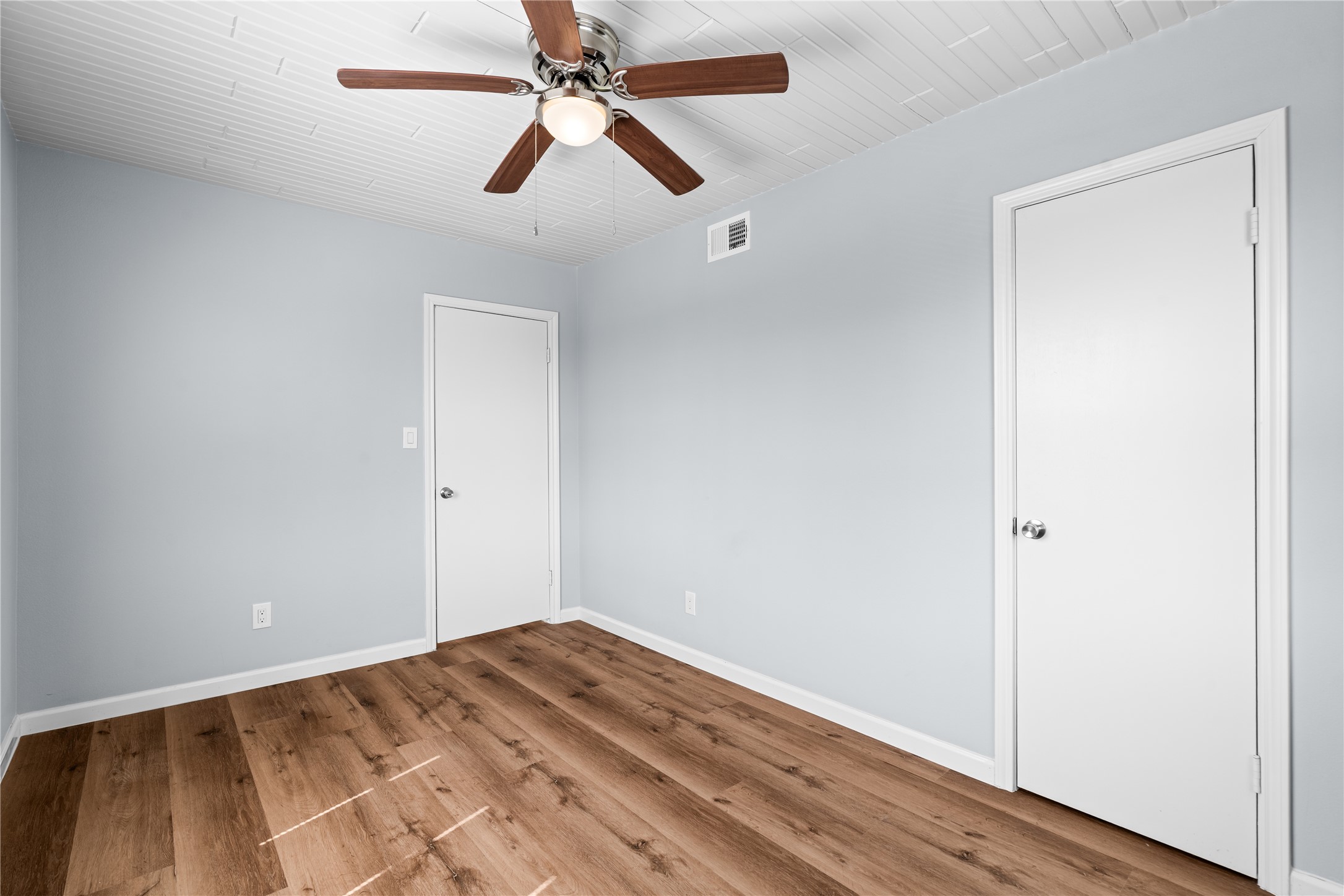 A bright and versatile room with dual windows that fill the space with natural light, creating a comfortable retreat for family, guests, or a dedicated home office.