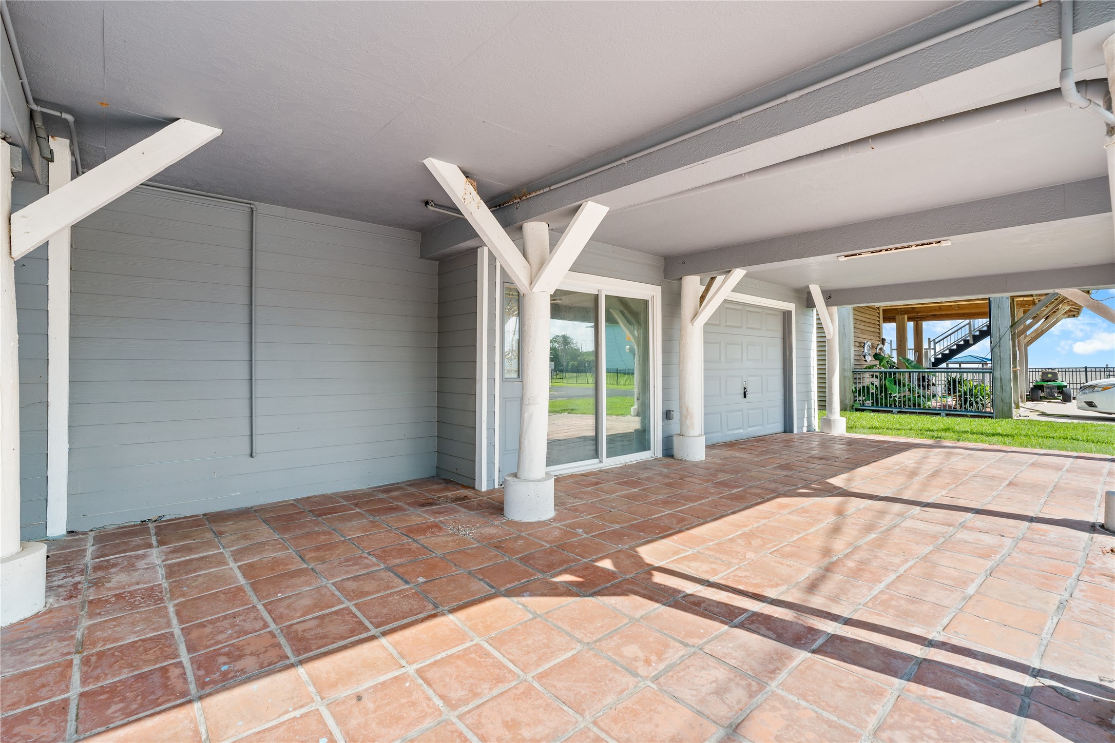 The expansive covered area beneath the home creates a versatile extension of the living space, perfect for entertaining, storing gear, or simply enjoying the shade after a day on the water.