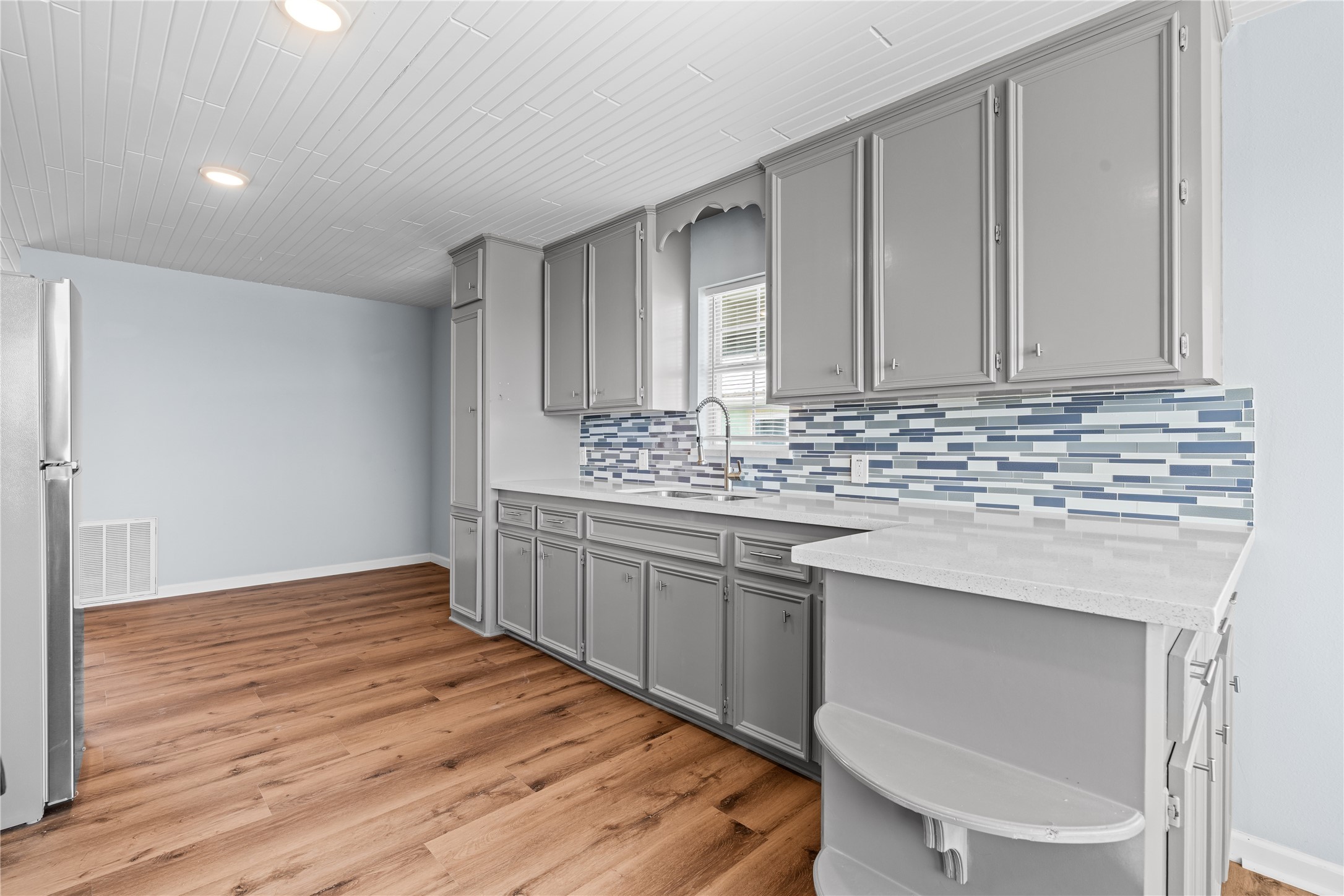 An extended run of quartz countertops, extensive cabinetry, and an open-concept layout create a kitchen designed for everyday ease.